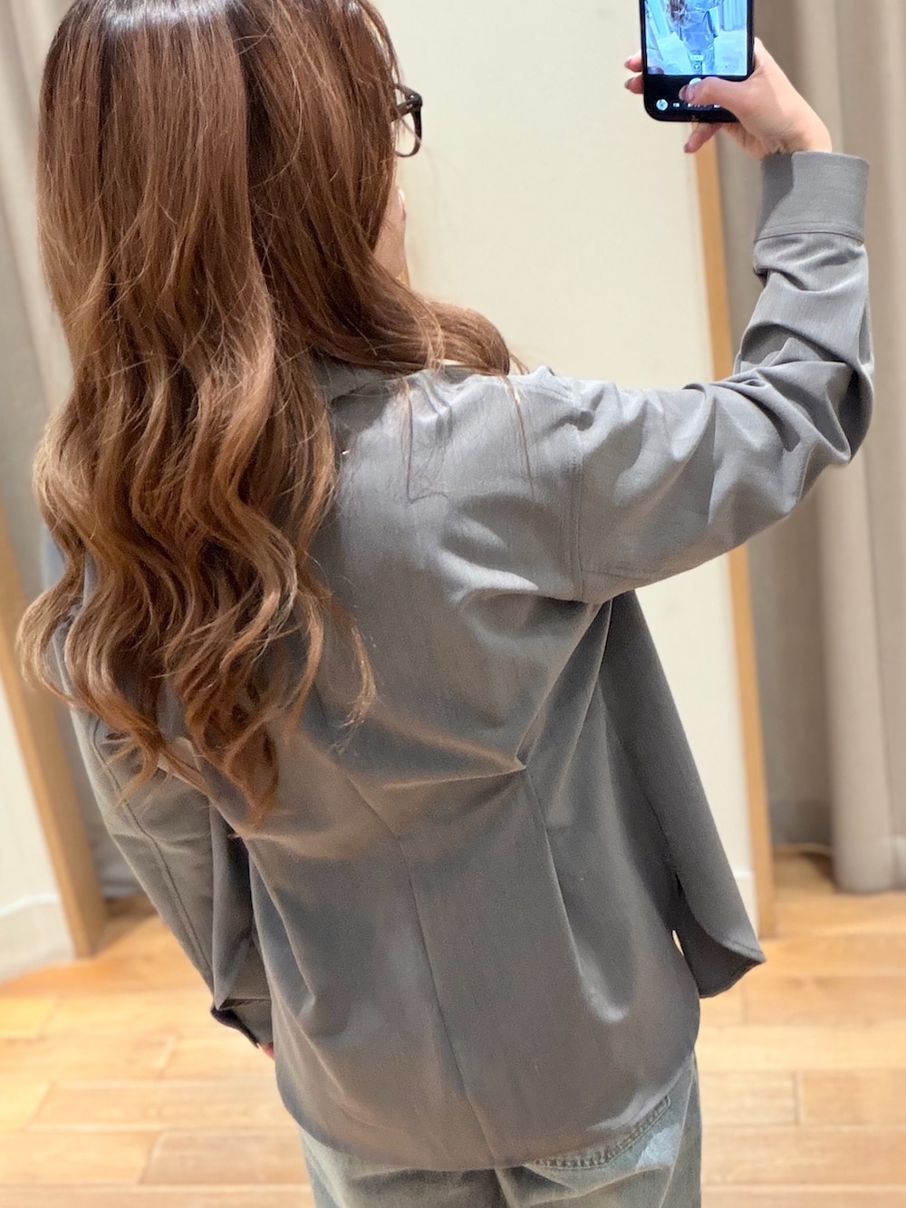 グレー系のシャツ/ブラウス、ブルー系のデニムパンツを着用したレディースの春コーディネートの3枚目の写真