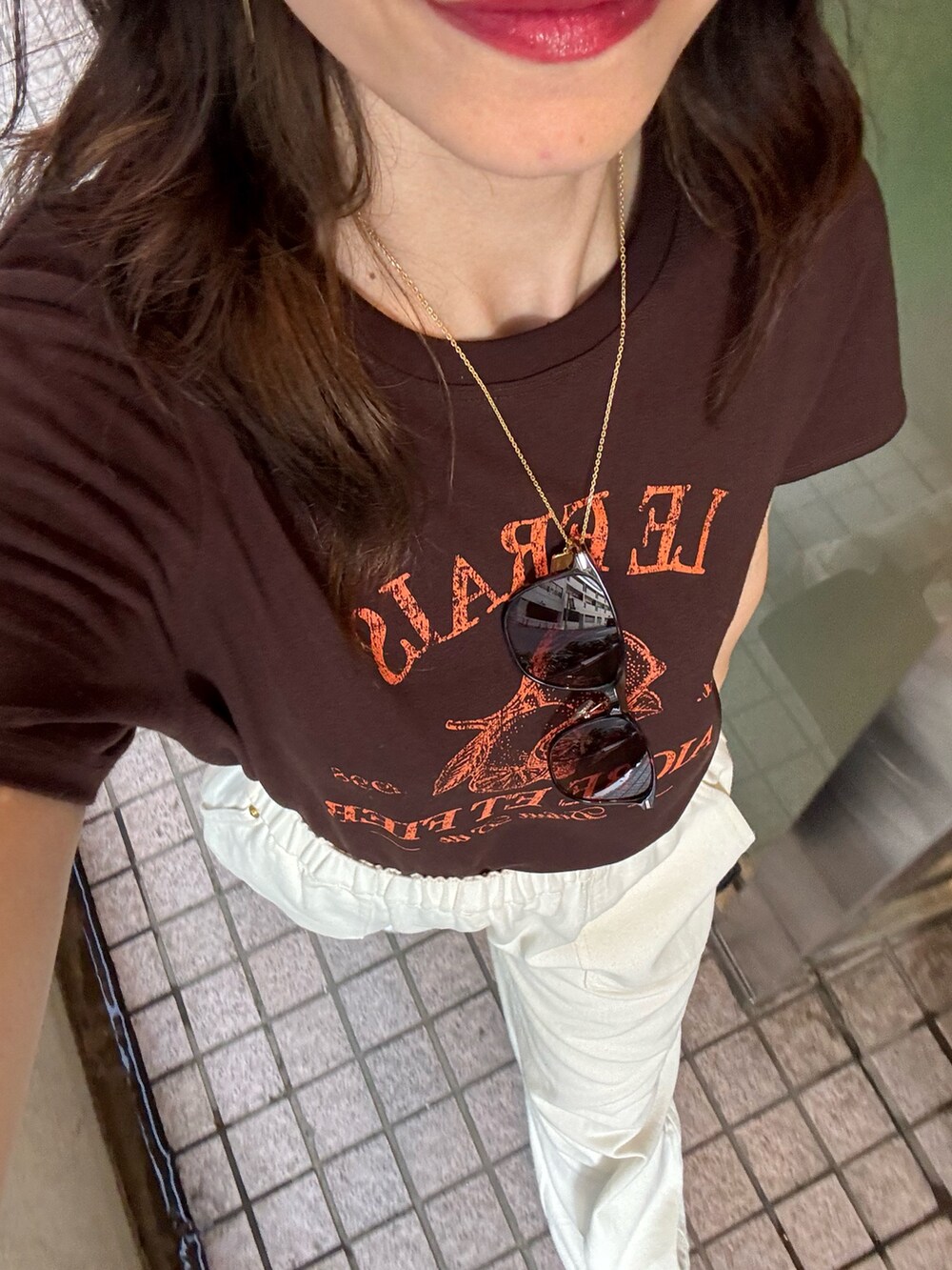 ブラウン系のTシャツ/カットソー、ホワイト系のデニムパンツ、ブラック系のショルダーバッグを着用したレディースの夏コーディネートの2枚目の写真