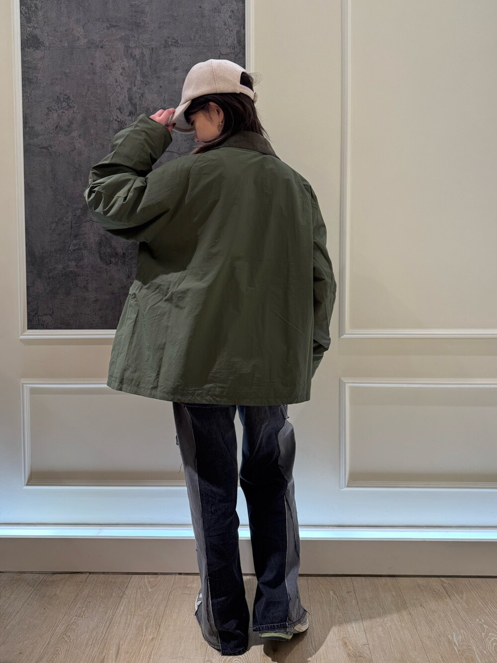 グリーン系のブルゾン、グレー系のニット/セーター、ブルー系のキャップを着用したレディースの秋コーディネートの4枚目の写真