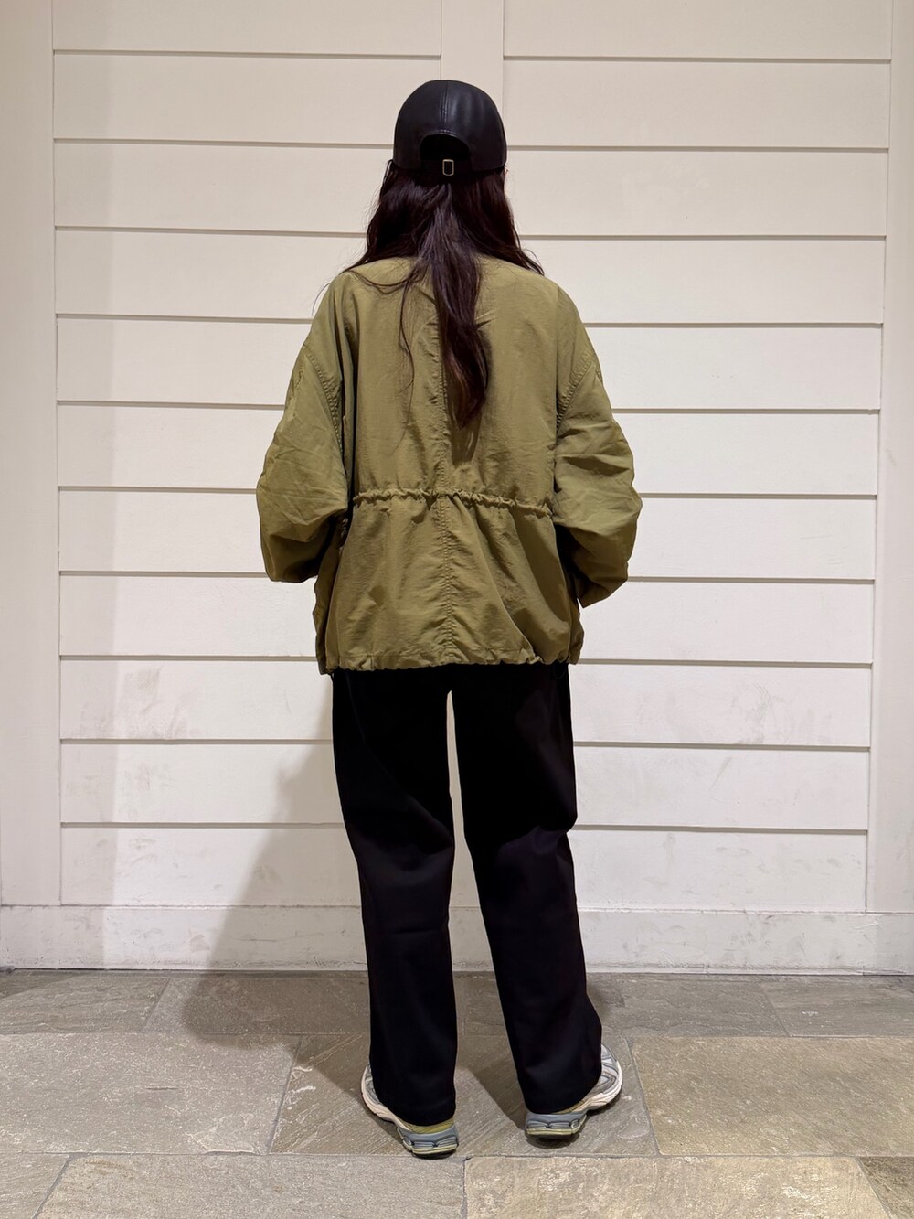 グリーン系のブルゾン、ブラック系のその他パンツ、ブラック系のキャップを着用したレディースの秋コーディネートの4枚目の写真