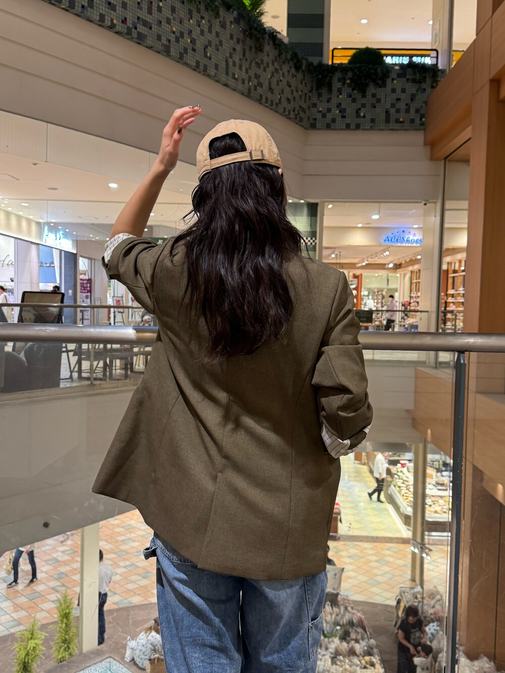 ブラウン系のテーラードジャケット、ブルー系のデニムパンツを着用したレディースの秋コーディネートの3枚目の写真