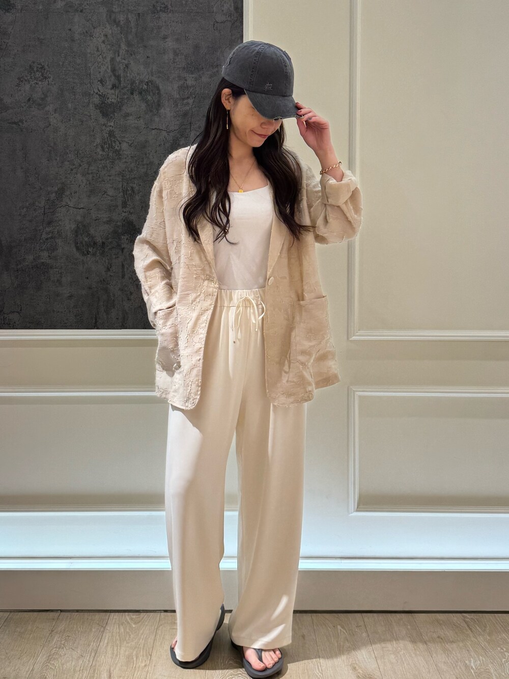 ベージュ系のテーラードジャケット、ブラック系のサンダル、ホワイト系のその他パンツを着用したレディースの春コーディネートの2枚目の写真