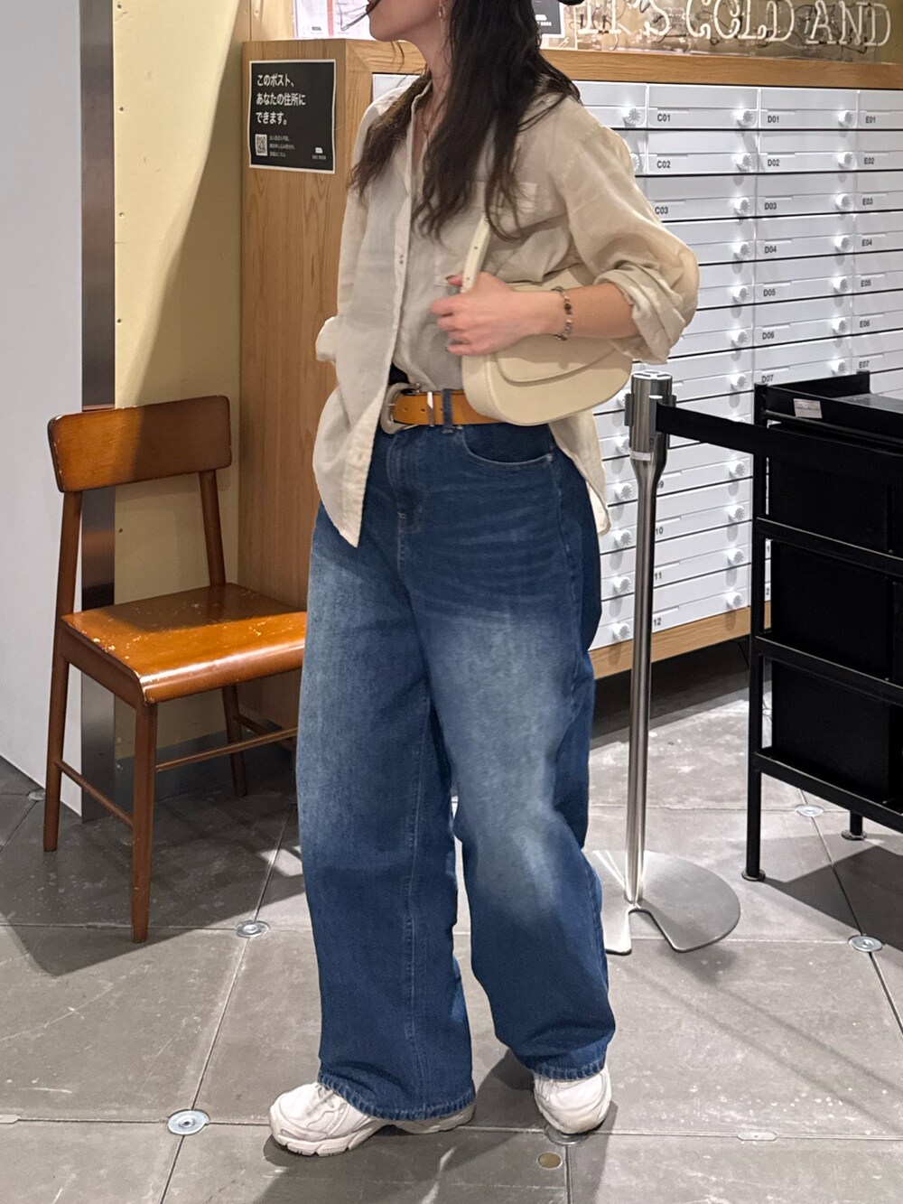 ベージュ系のシャツ/ブラウス、ブルー系のデニムパンツを着用したレディースの春コーディネートの5枚目の写真