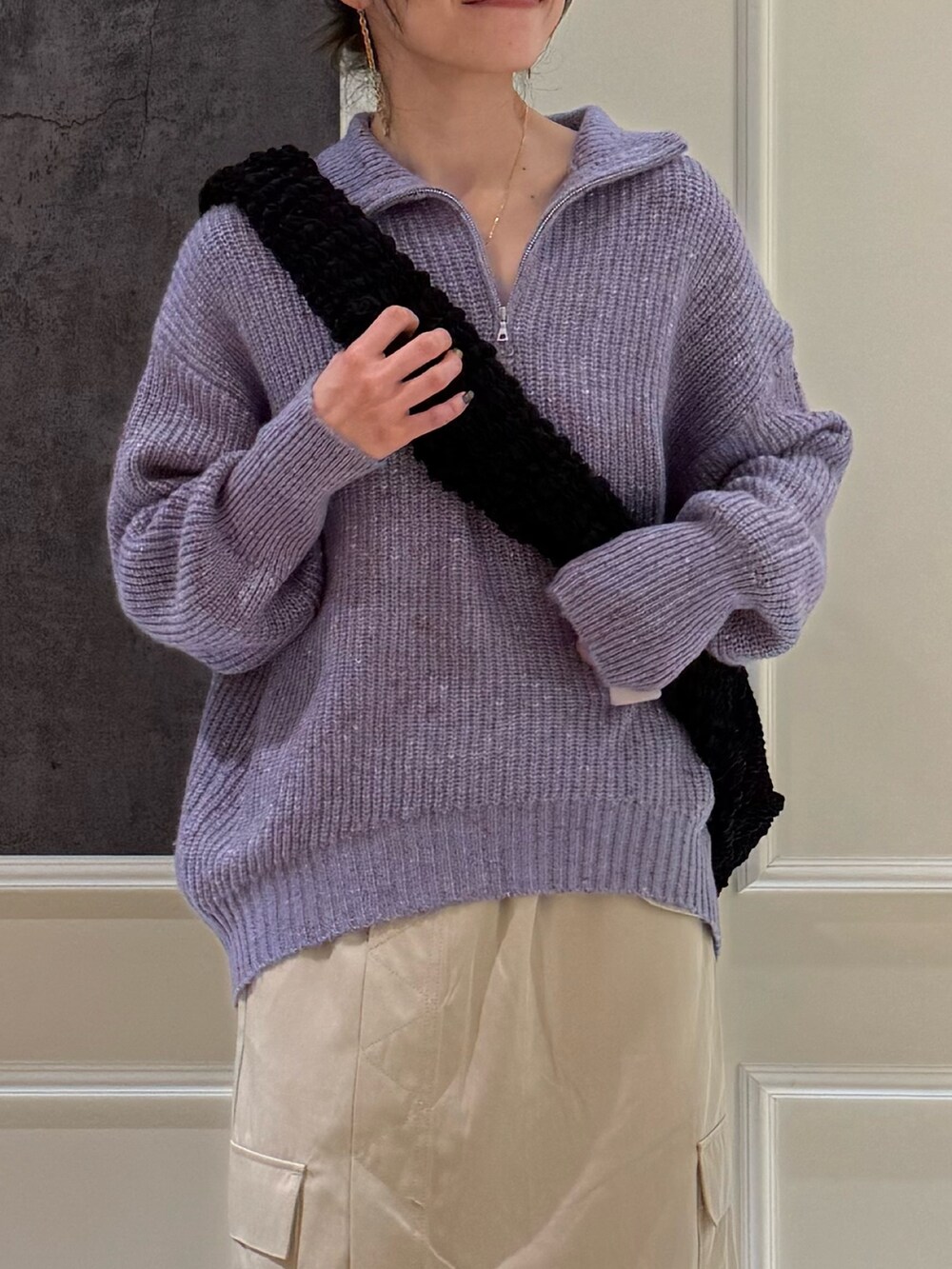 パープル系のニット/セーター、ホワイト系のスカートを着用したレディースの冬コーディネートの2枚目の写真