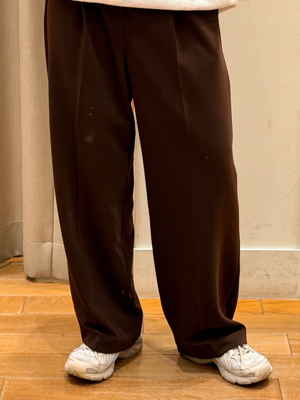 グレー系のTシャツ/カットソー、ブラウン系のショルダーバッグ、ブラウン系のスラックスを着用したレディースの秋コーディネートの5枚目の写真