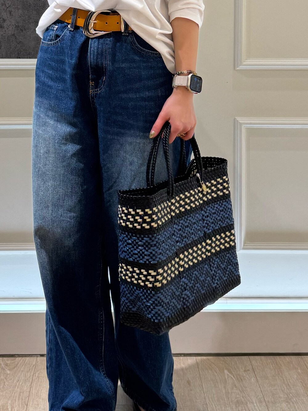 ホワイト系のTシャツ/カットソー、ブルー系のデニムパンツ、ブラック系のかごバッグを着用したレディースの春コーディネートの3枚目の写真