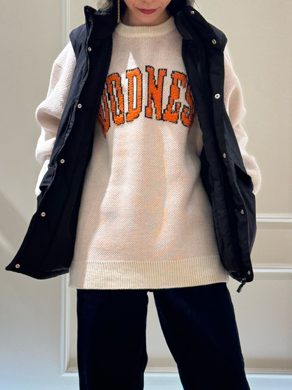 ブラック系のベスト、ホワイト系のニット/セーター、ベージュ系のハットを着用したレディースの秋コーディネートの2枚目の写真