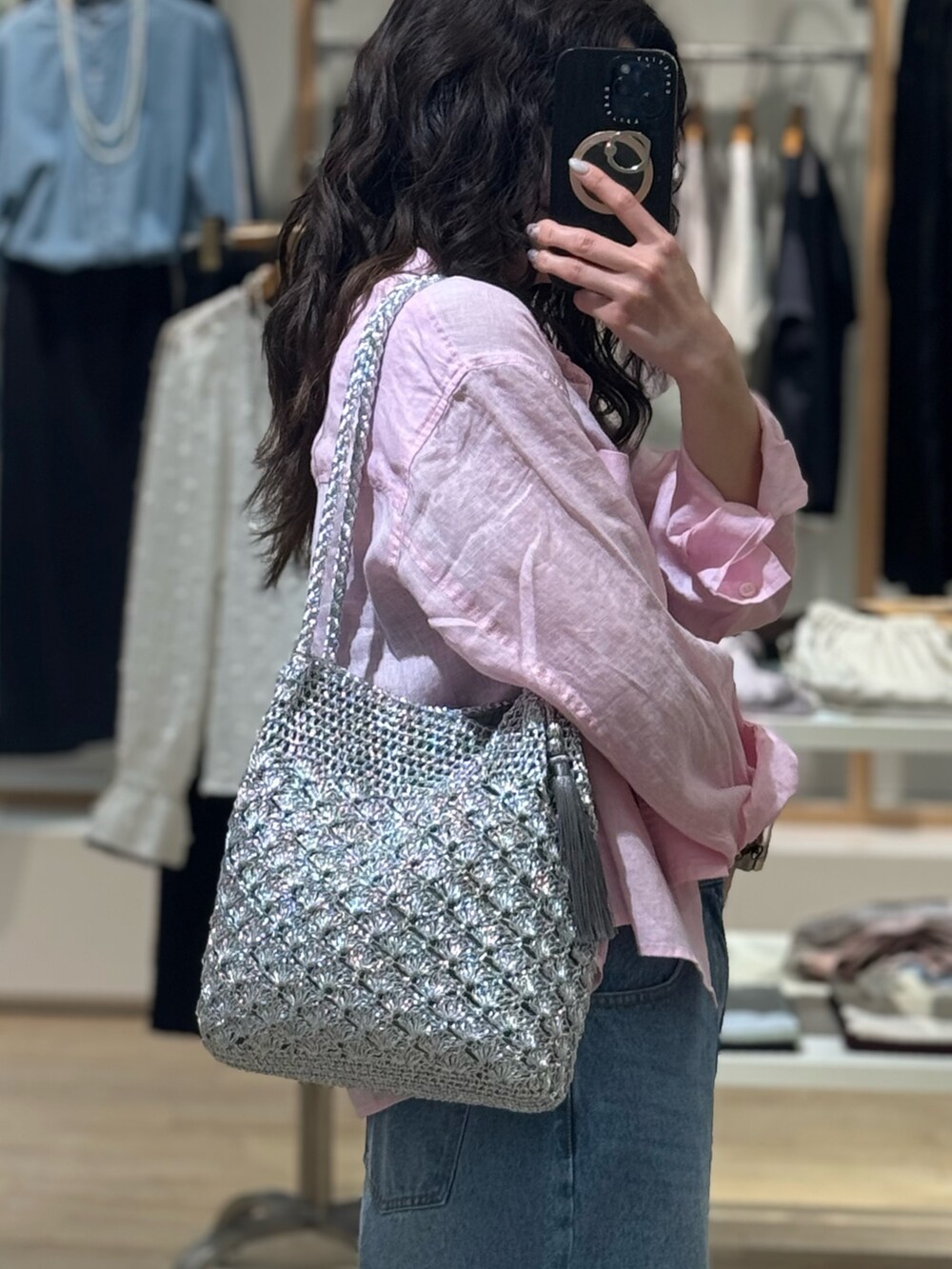 ピンク系のシャツ/ブラウス、ブルー系のデニムパンツ、シルバー系のかごバッグを着用したレディースの春コーディネートの3枚目の写真