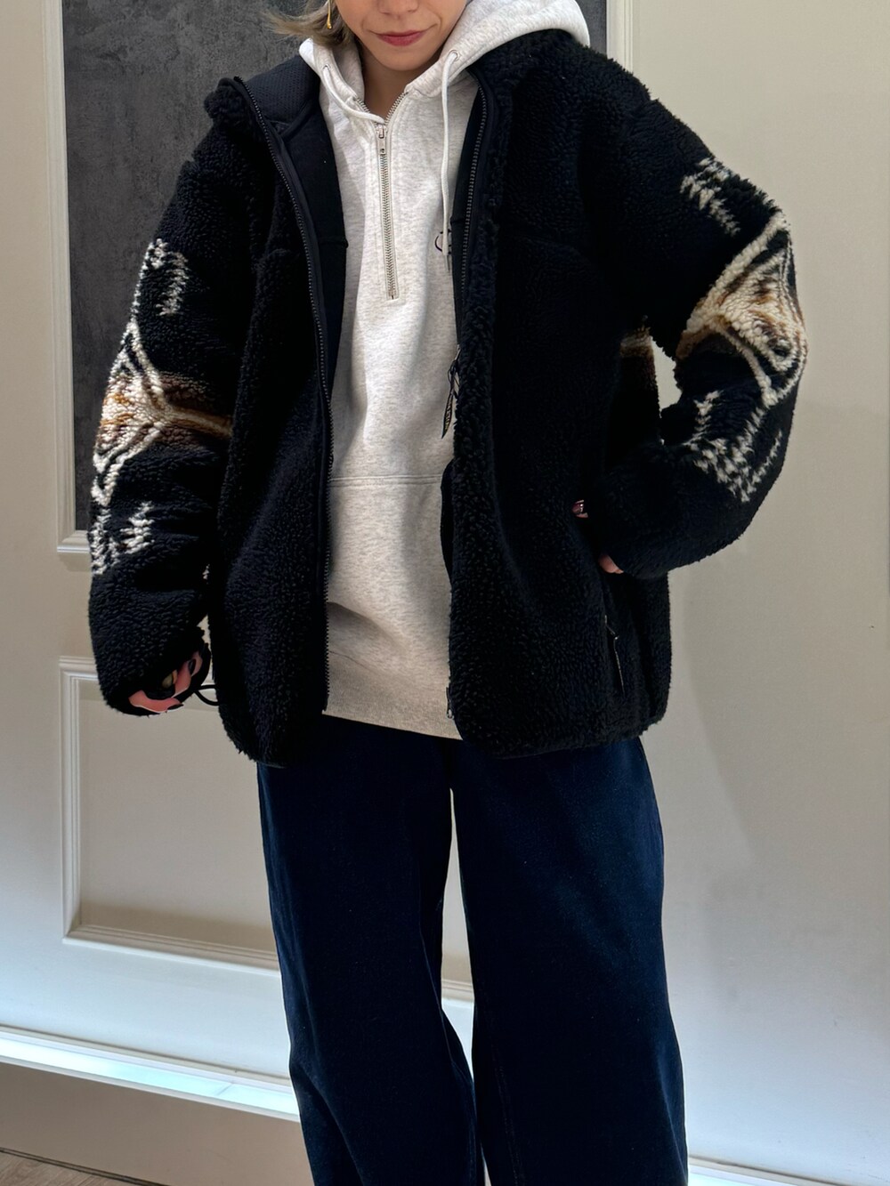 ホワイト系のパーカー、ホワイト系のブルゾン、グレー系のサンダルを着用したレディースの秋コーディネートの2枚目の写真