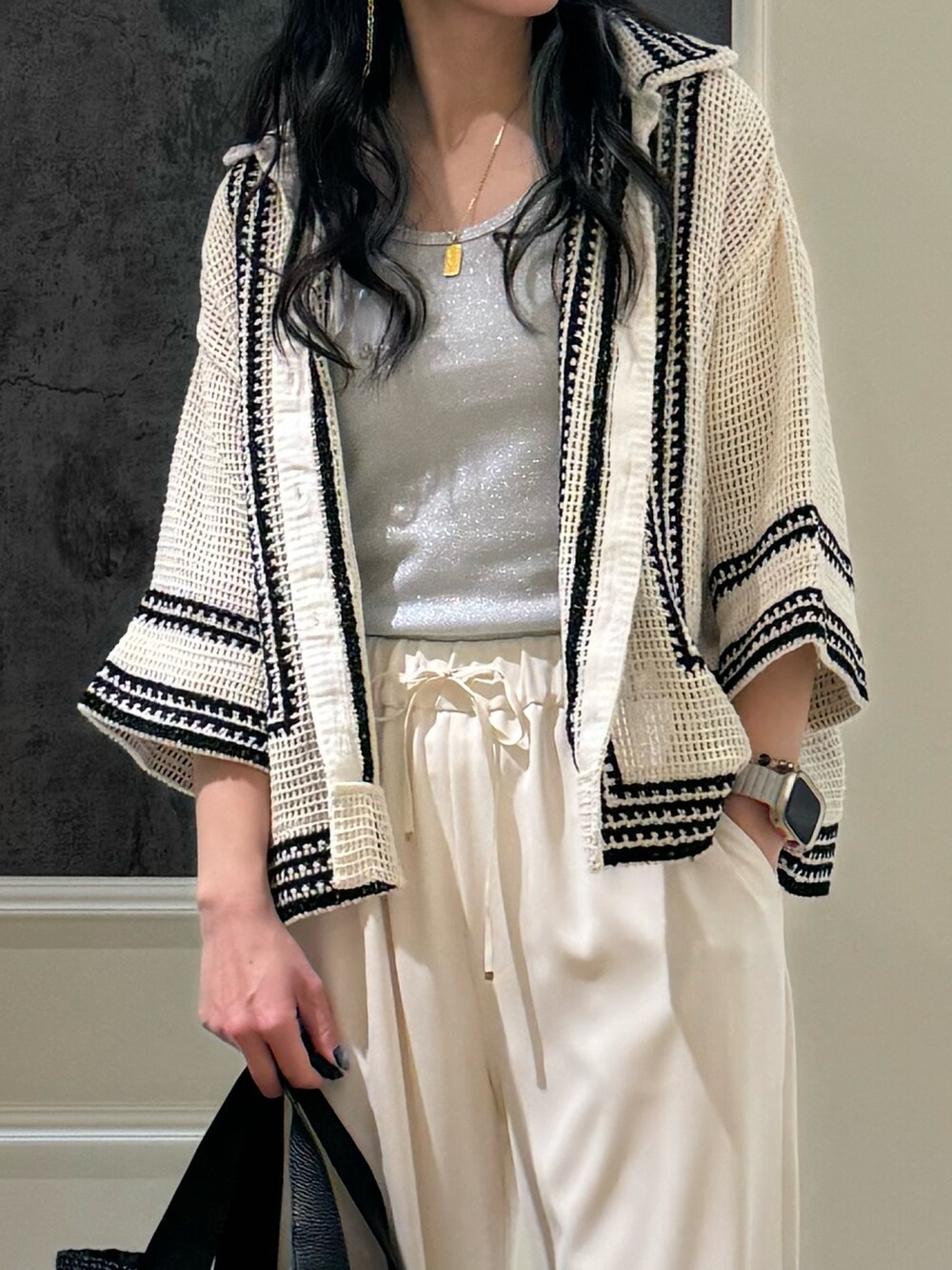 ブラック系のトートバッグ、シルバー系のTシャツ/カットソー、ホワイト系のシャツ/ブラウスを着用したレディースの春コーディネートの2枚目の写真