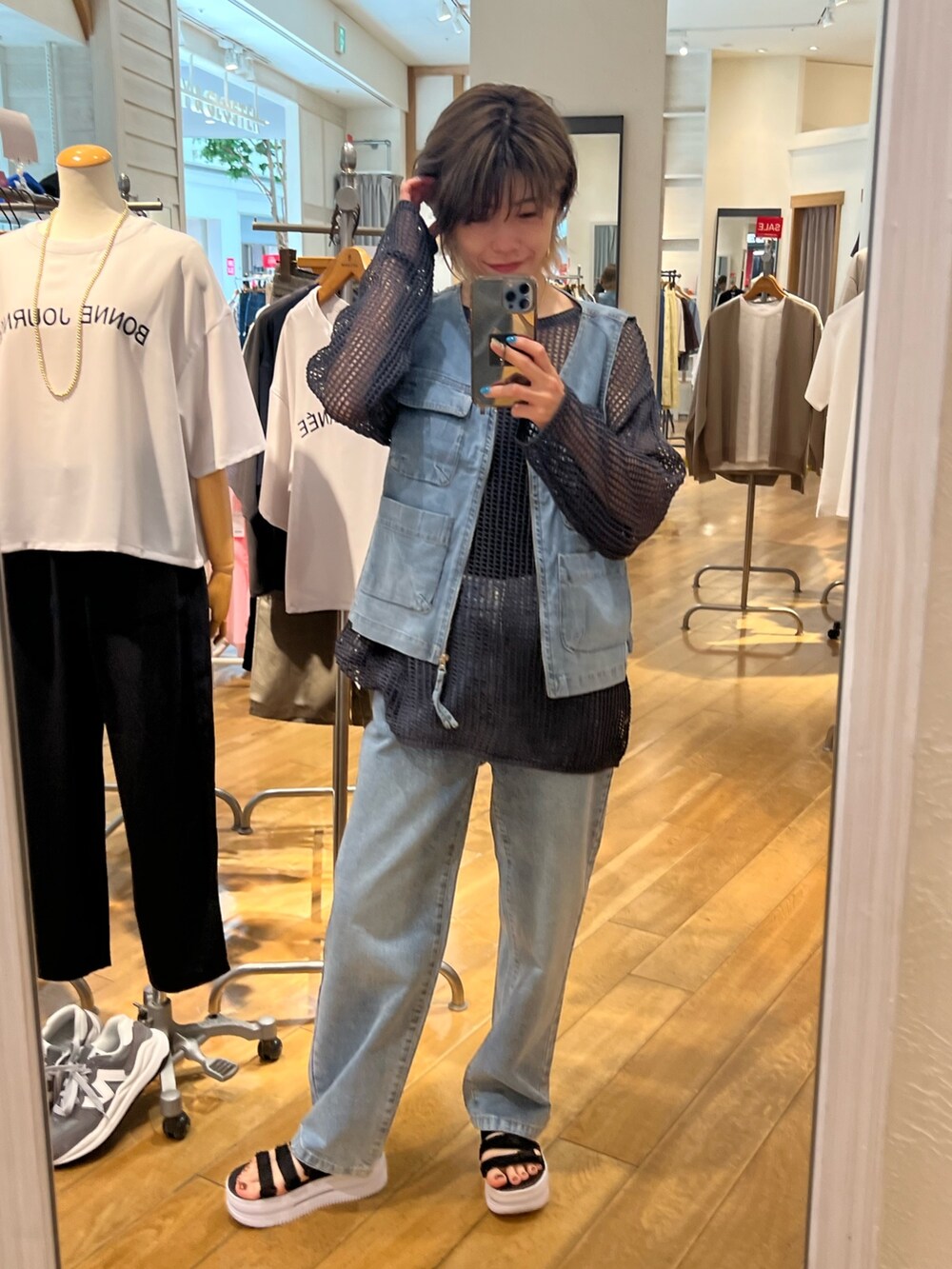 グレー系のニット/セーター、ブルー系のデニムパンツ、ブルー系のデニムジャケットを着用したレディースの夏コーディネートの2枚目の写真