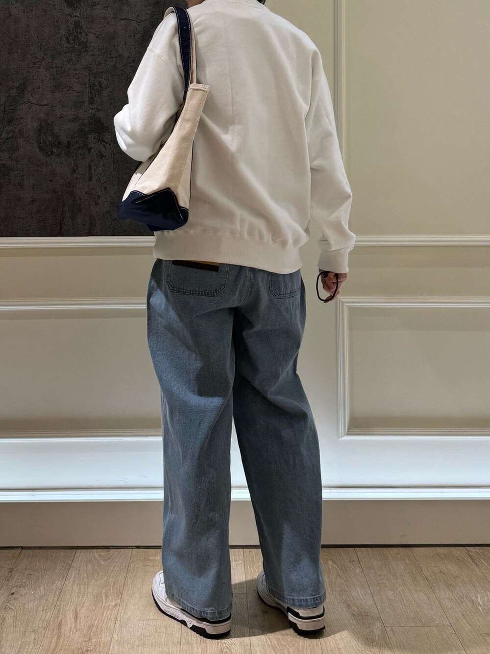 ブルー系のトートバッグ、ホワイト系のスウェット、ブルー系のデニムパンツを着用したレディースの春コーディネートの4枚目の写真