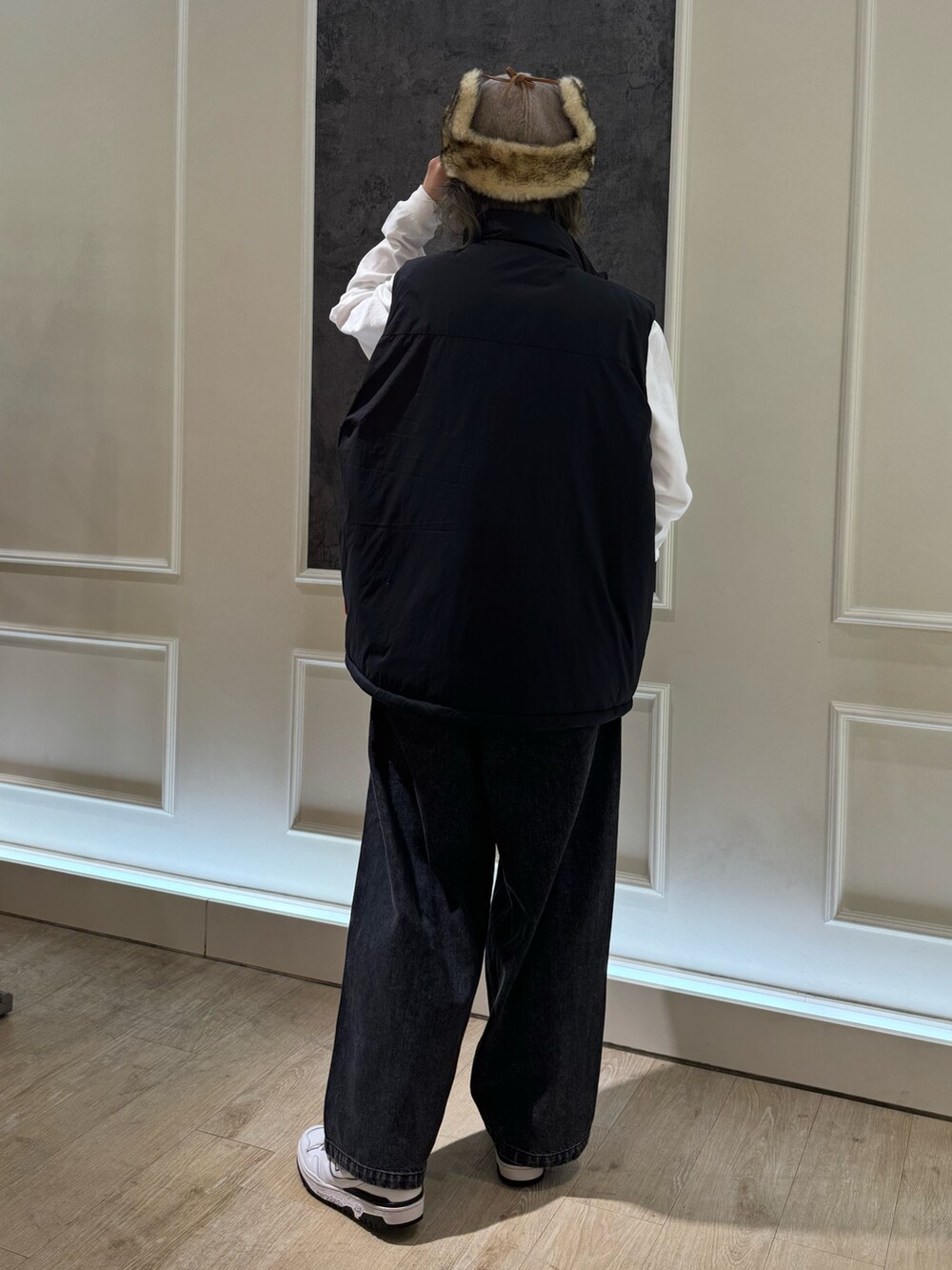 ブラック系のベスト、ホワイト系のTシャツ/カットソー、ブラック系のデニムパンツを着用したレディースの秋コーディネートの3枚目の写真