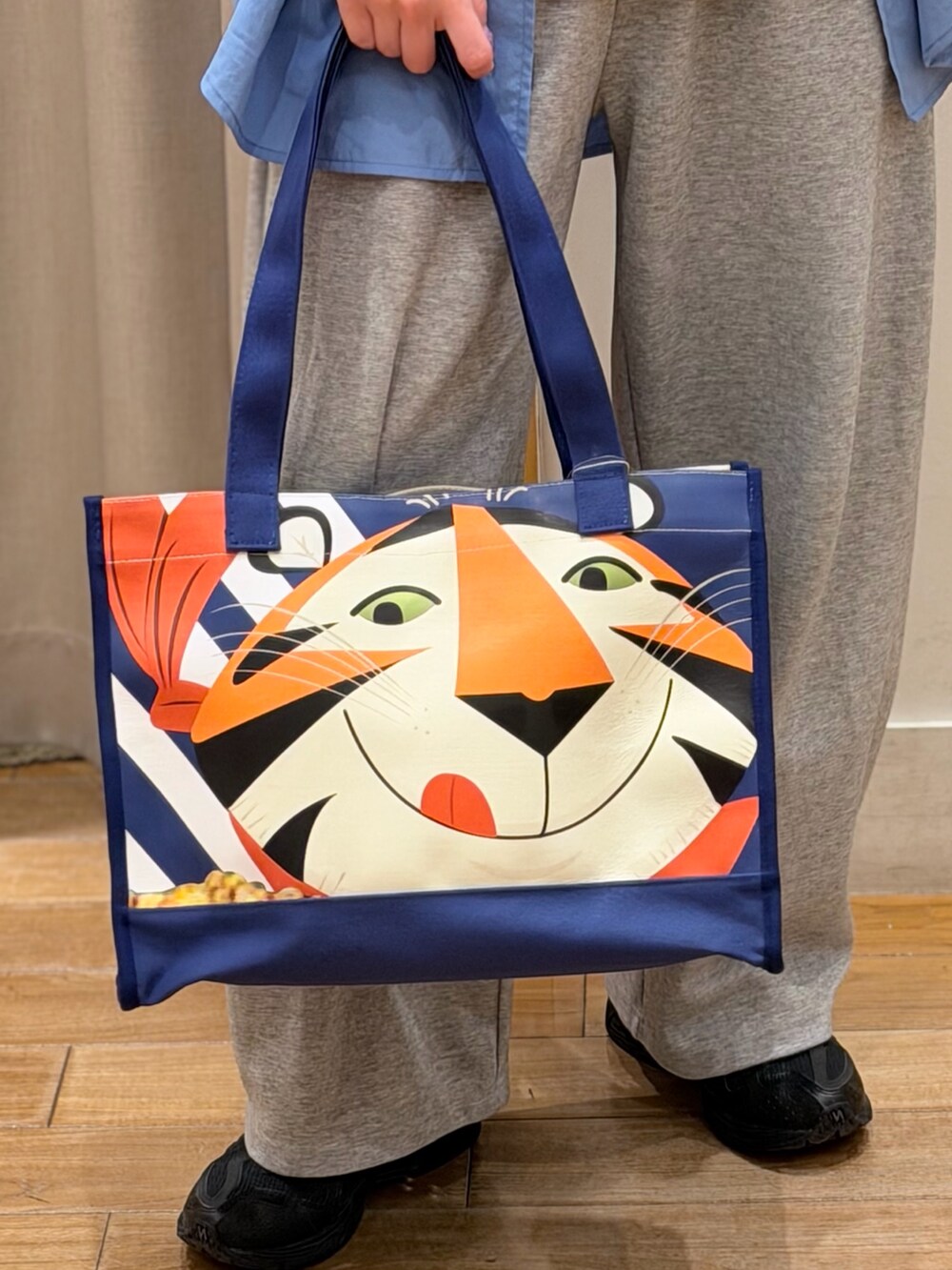 ブルー系のシャツ/ブラウス、ブルー系のトートバッグ、ホワイト系のTシャツ/カットソーを着用したレディースの春コーディネートの4枚目の写真