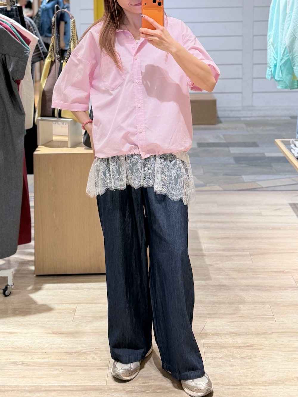 ピンク系のシャツ/ブラウス、ホワイト系のタンクトップ、ブルー系のデニムパンツを着用したレディースの夏コーディネートの2枚目の写真