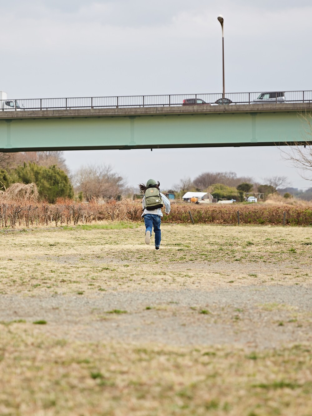 グレー系のトップス、ブルー系のデニムパンツ、グリーン系のバックパック/リュックを着用したキッズの春コーディネートの2枚目の写真