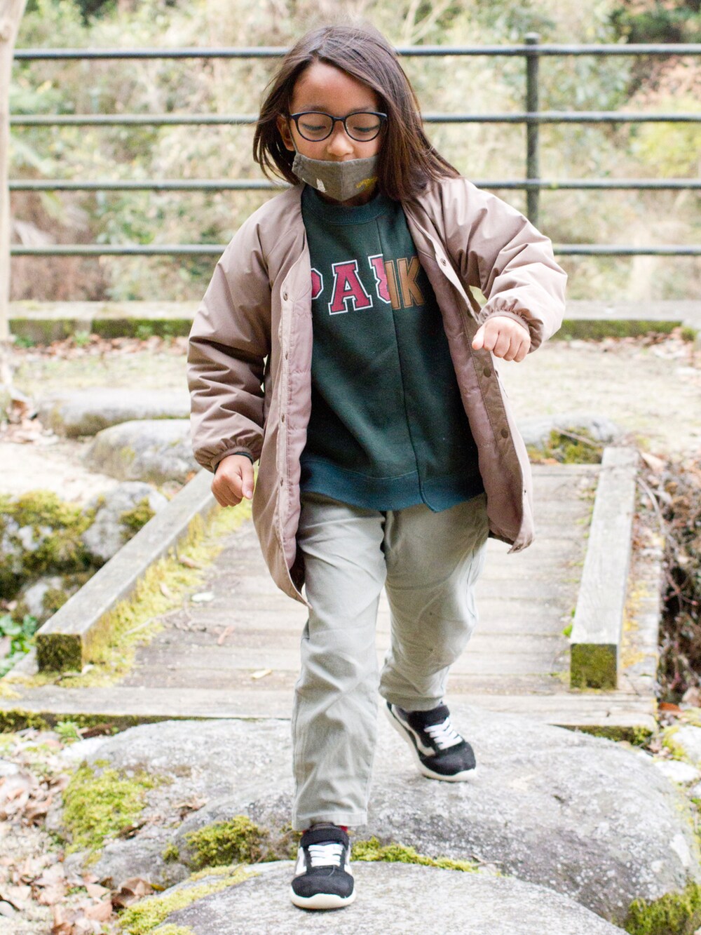 ベージュ系のジャケット/アウター、グリーン系のパンツ、ブラック系のスニーカーを着用したキッズの春コーディネートの2枚目の写真