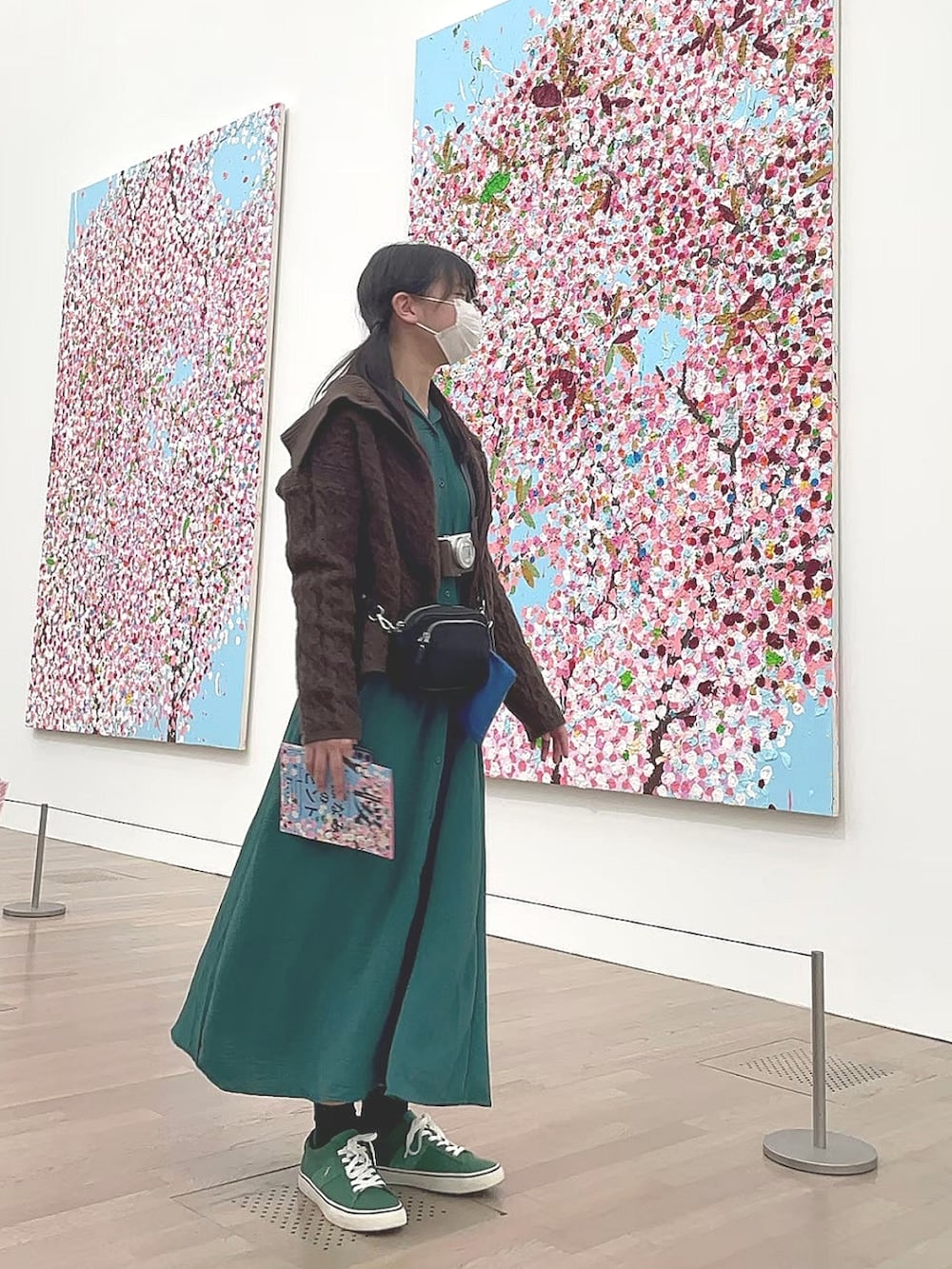 グリーン系のワンピース、グリーン系のスニーカー、ブラウン系のカーディガン/ボレロを着用したレディースの秋コーディネートの3枚目の写真