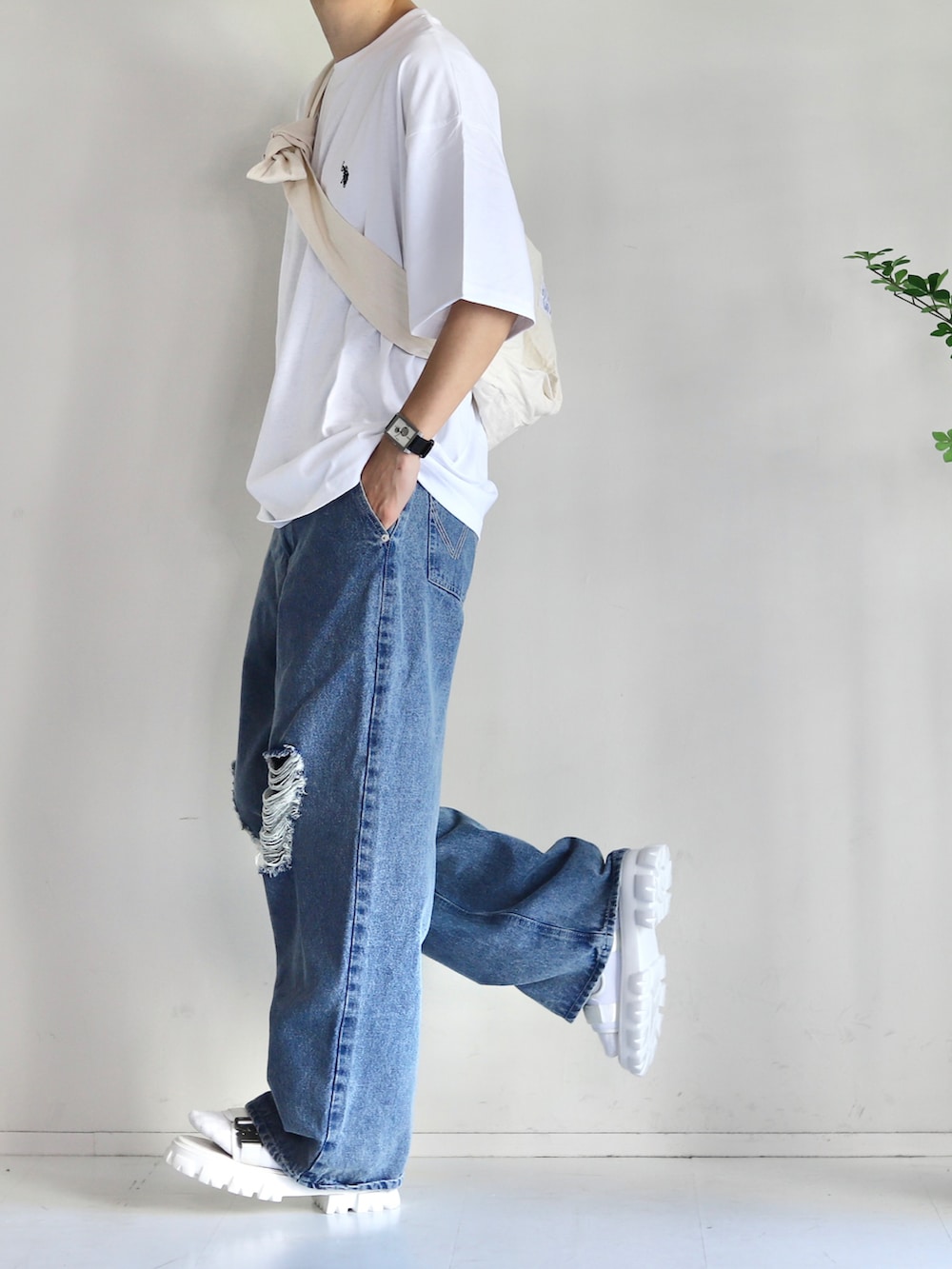 ホワイト系のTシャツ/カットソー、ブルー系のデニムパンツ、ホワイト系のサンダルを着用したメンズの春コーディネートの3枚目の写真