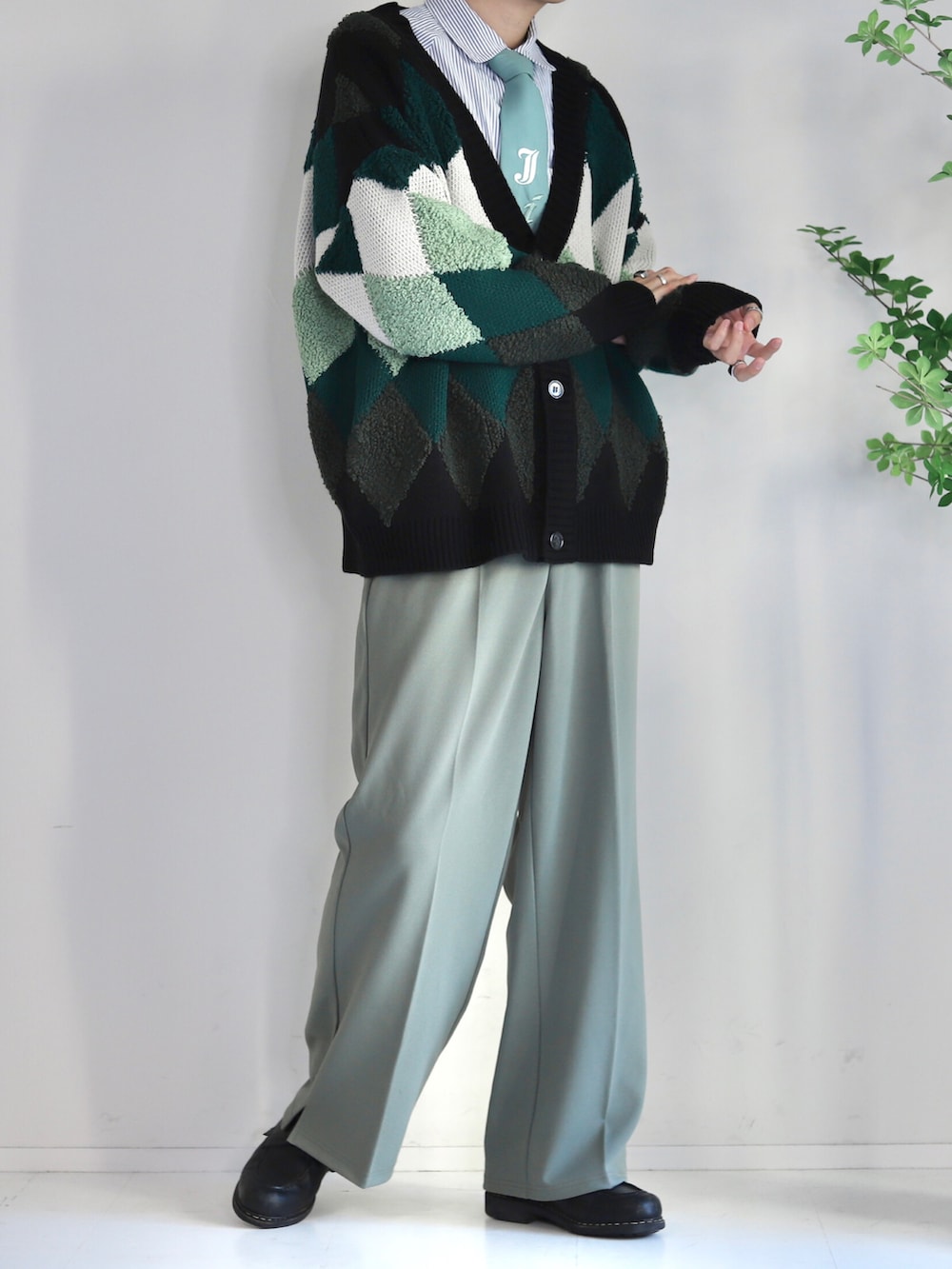 グリーン系のネクタイ、グリーン系のスラックス、グリーン系のカーディガン/ボレロを着用したメンズの冬コーディネートの2枚目の写真