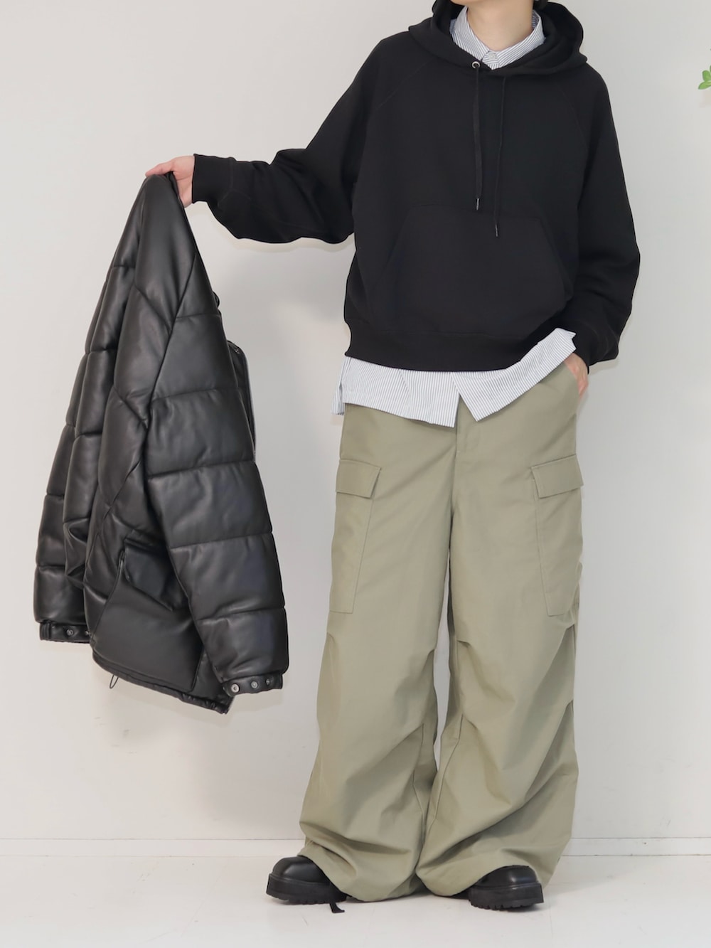 グリーン系のカーゴパンツ、ブラック系のブーツ、ブラック系のダウンジャケット/コートを着用したメンズの冬コーディネートの2枚目の写真