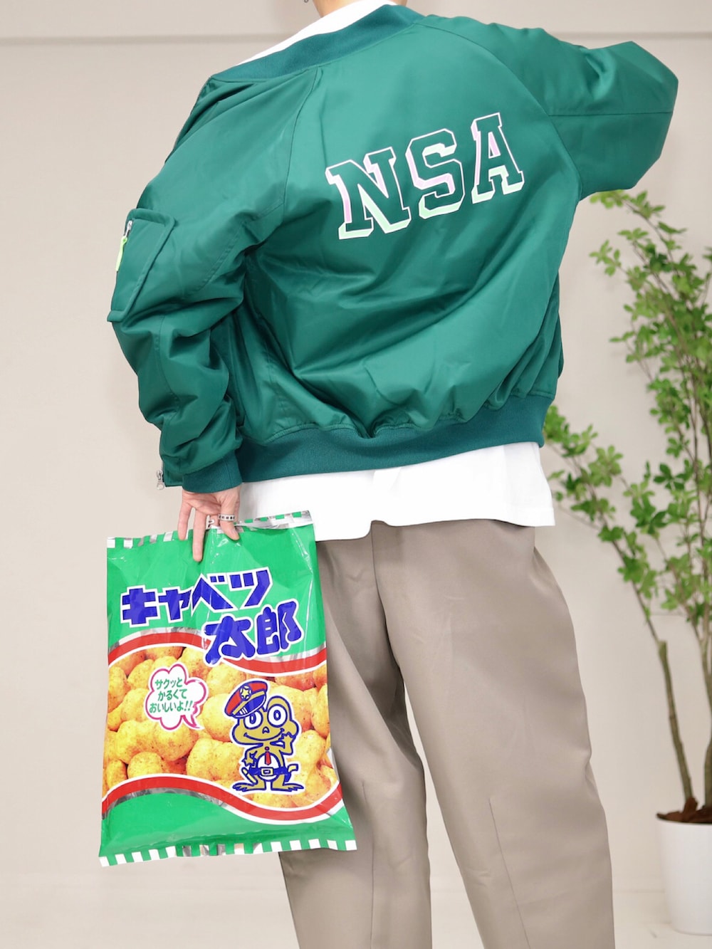 グリーン系のその他アウター、ベージュ系のパンツ、グリーン系のスニーカーを着用したメンズの春コーディネートの3枚目の写真