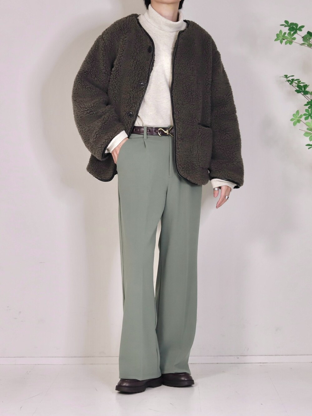 ベージュ系のニット/セーター、グリーン系のスラックス、ブラウン系のブルゾンを着用したメンズの春コーディネートの2枚目の写真