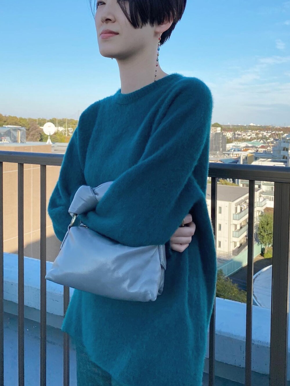 グリーン系のニット/セーター、グリーン系のデニムパンツを着用したレディースの冬コーディネートの2枚目の写真