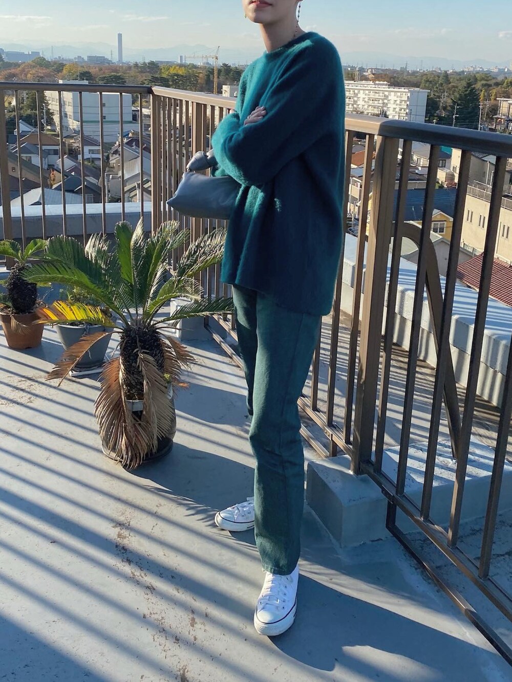 グリーン系のニット/セーター、グリーン系のデニムパンツを着用したレディースの冬コーディネートの3枚目の写真