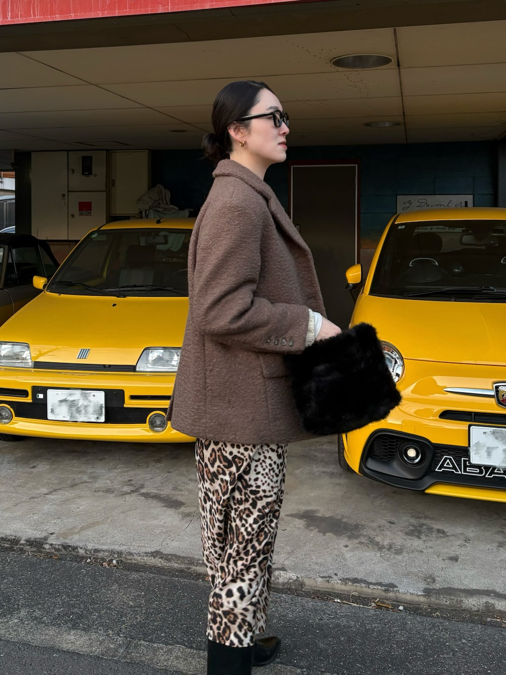 ブラウン系のジャケット/アウター、ブラウン系のバッグ、ブラック系のブーツを着用したレディースの冬コーディネートの2枚目の写真