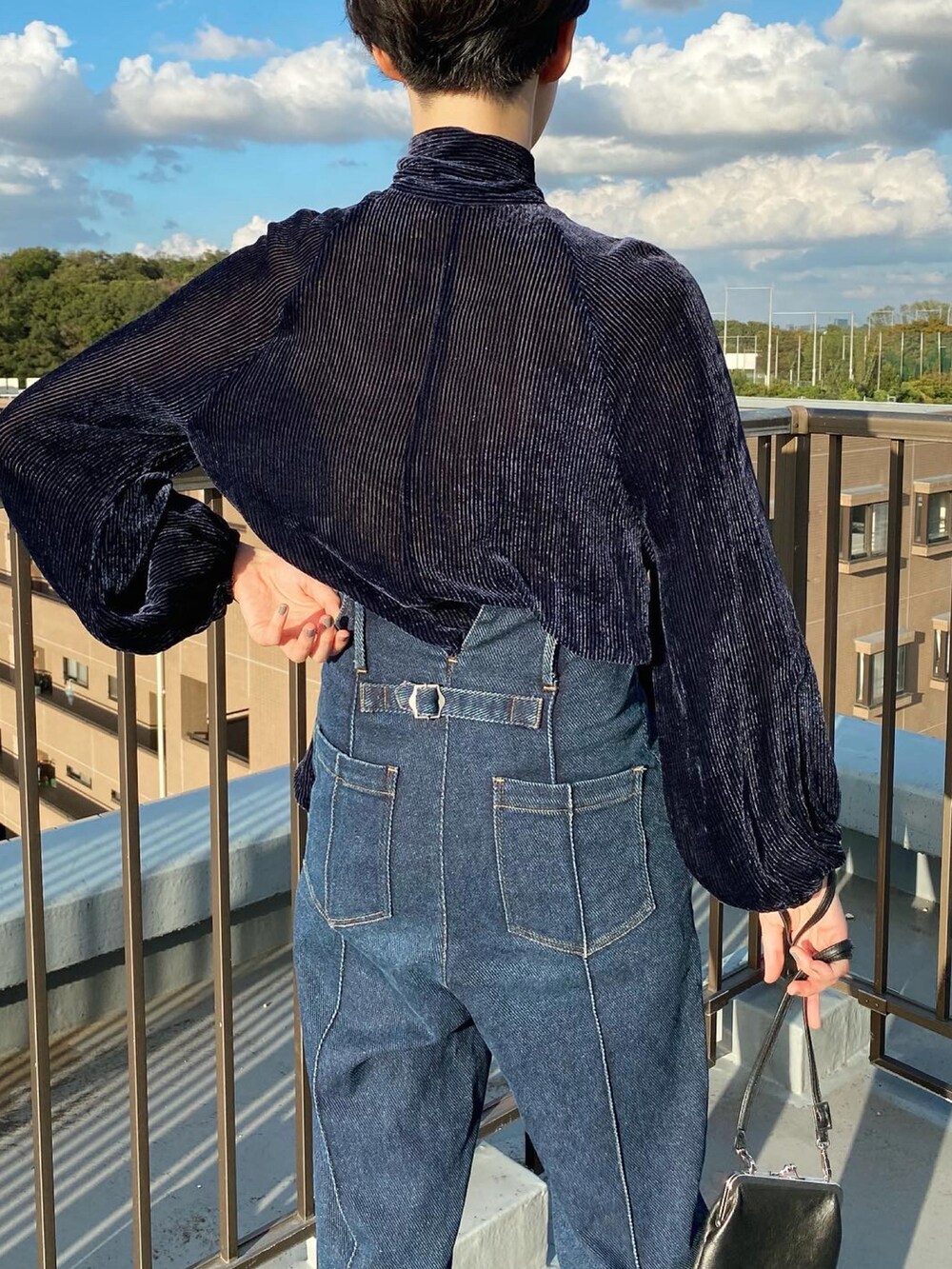 ブルー系のデニムパンツ、ブルー系のシャツ/ブラウス、ブラック系のショルダーバッグを着用したレディースの秋コーディネートの4枚目の写真