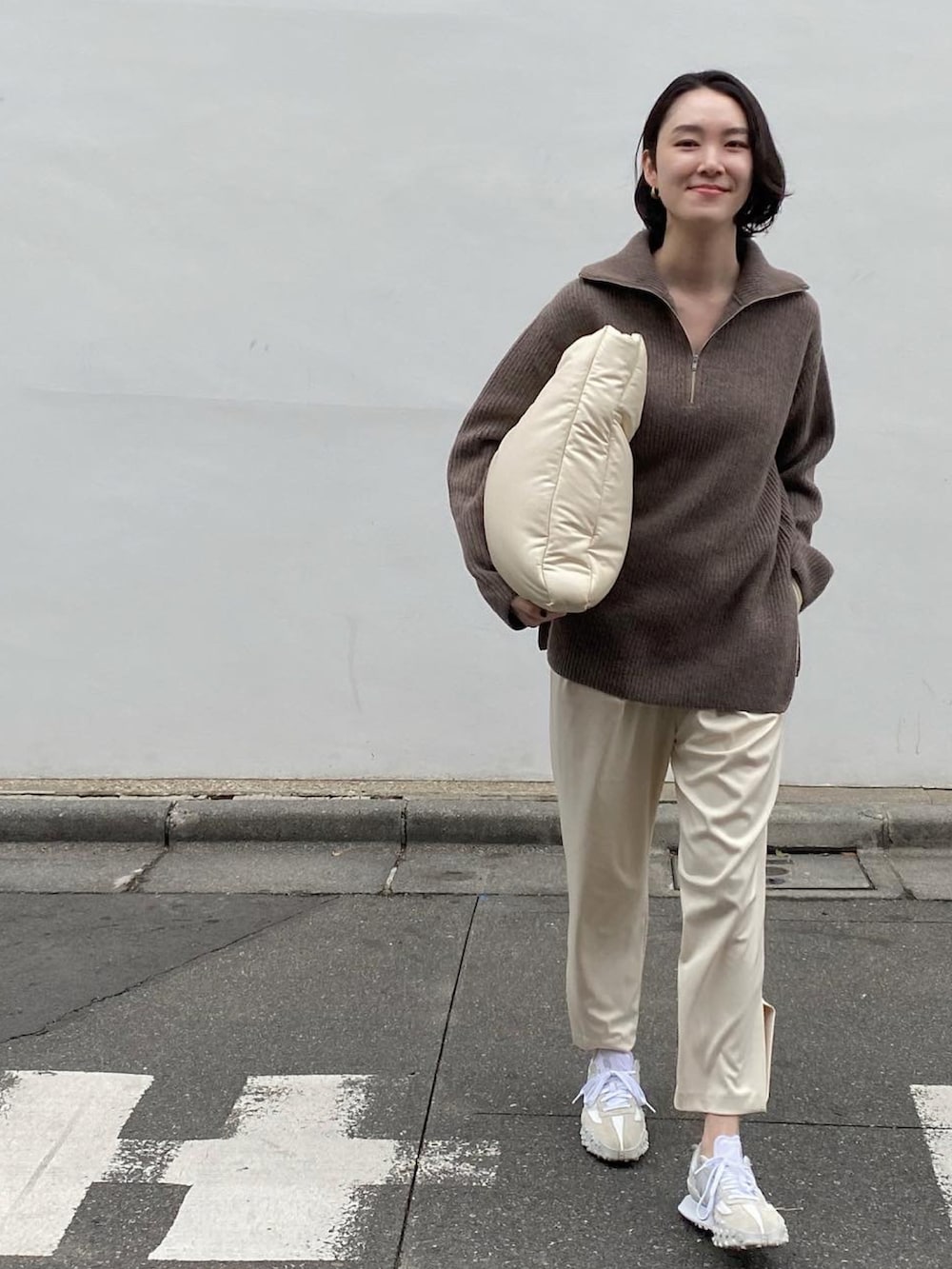 ホワイト系のバッグ、ホワイト系のパンツ、ホワイト系のスニーカーを着用したレディースの冬コーディネートの3枚目の写真