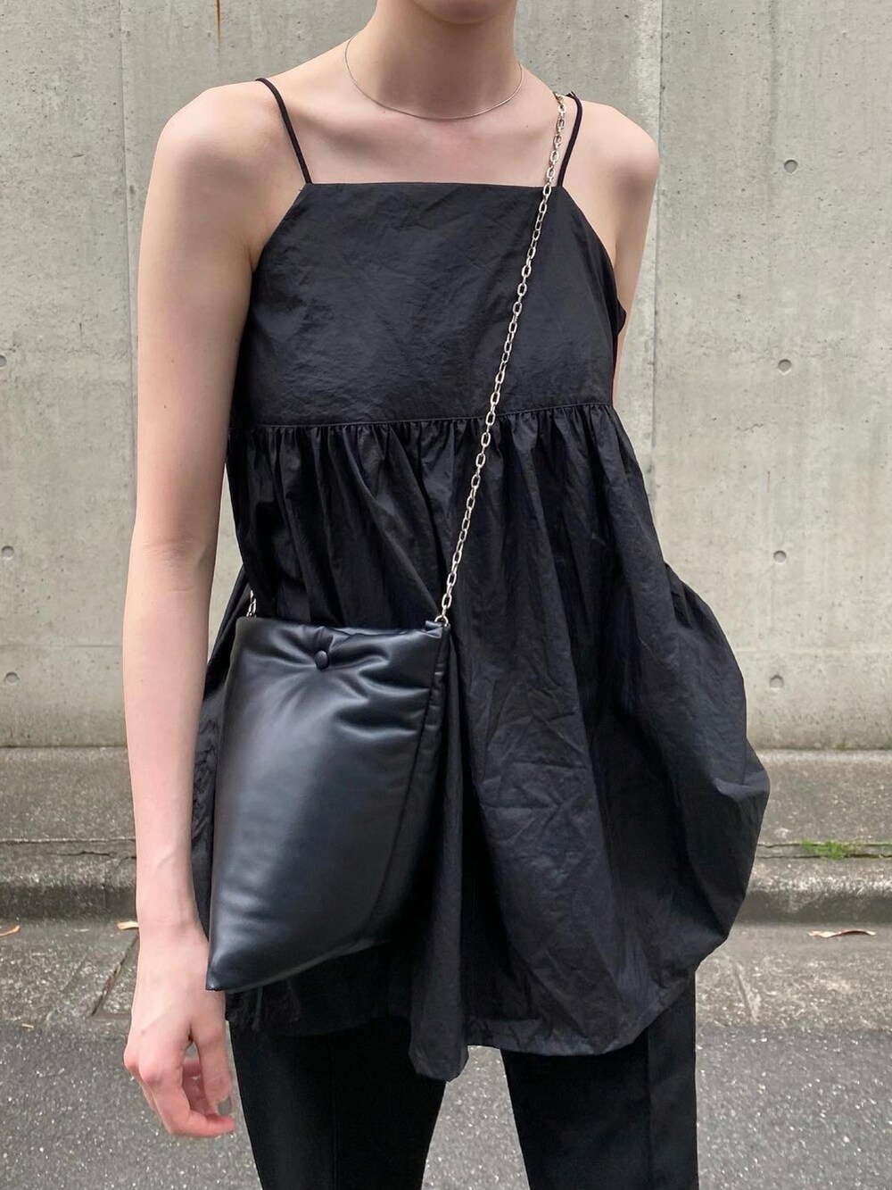 ブラック系のトートバッグ、ブラック系のパンツ、ブラック系のキャミソールを着用したレディースの春コーディネートの3枚目の写真