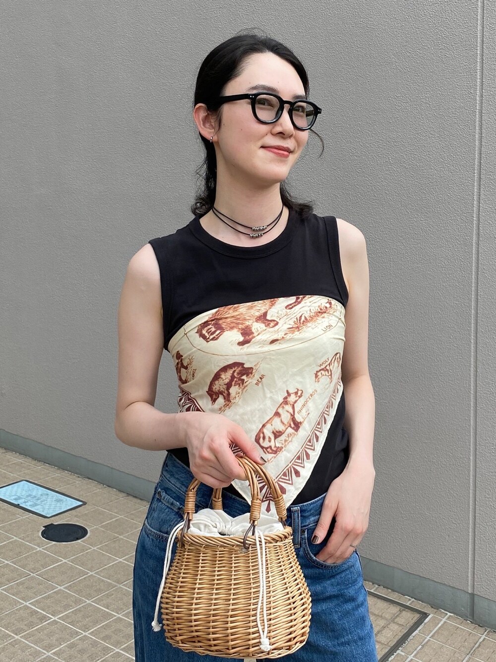 ベージュ系のかごバッグ、ブルー系のデニムパンツ、レッド系のパンプスを着用したレディースの夏コーディネートの5枚目の写真