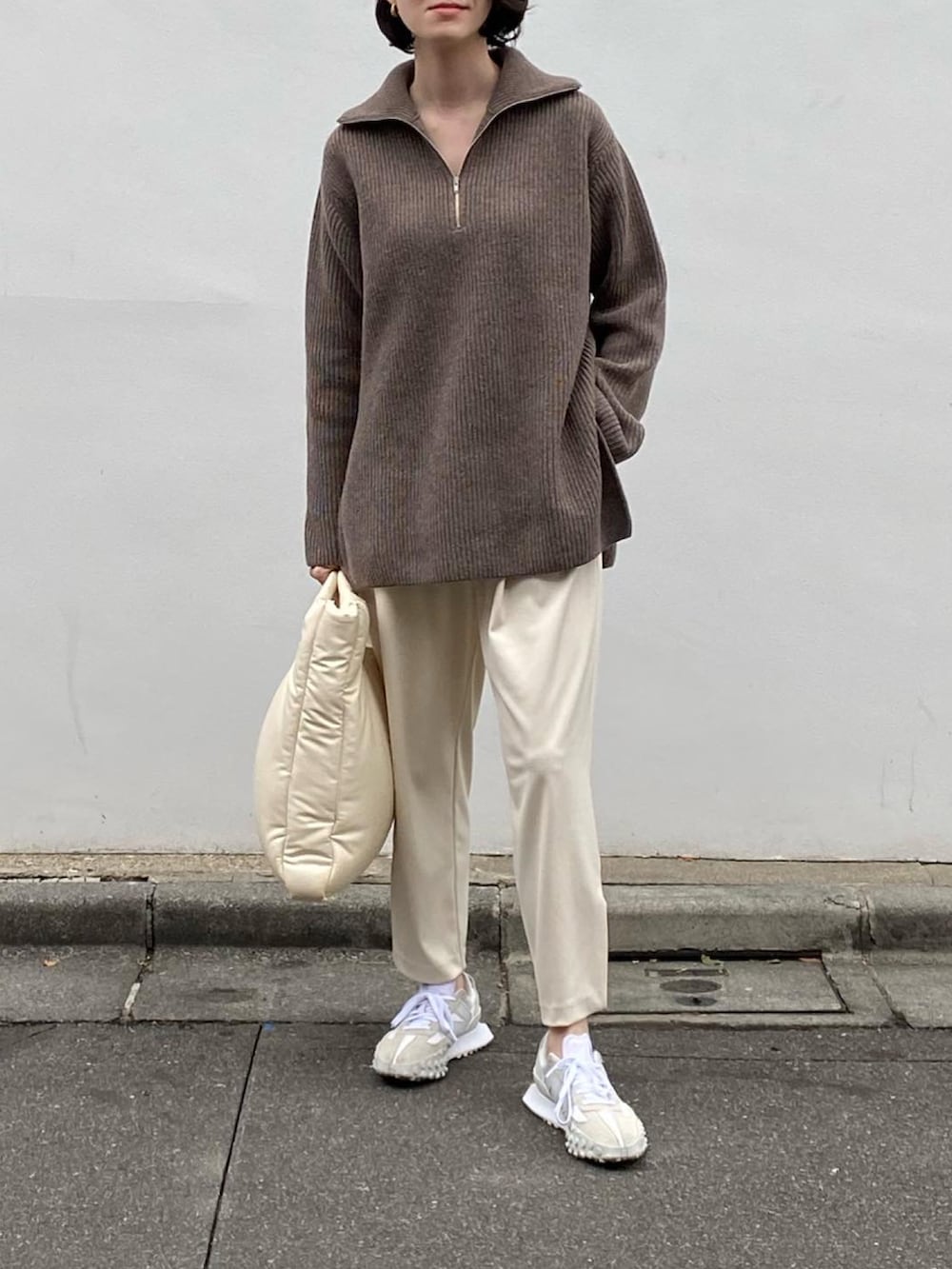 ホワイト系のバッグ、ホワイト系のパンツ、ホワイト系のスニーカーを着用したレディースの冬コーディネートの2枚目の写真