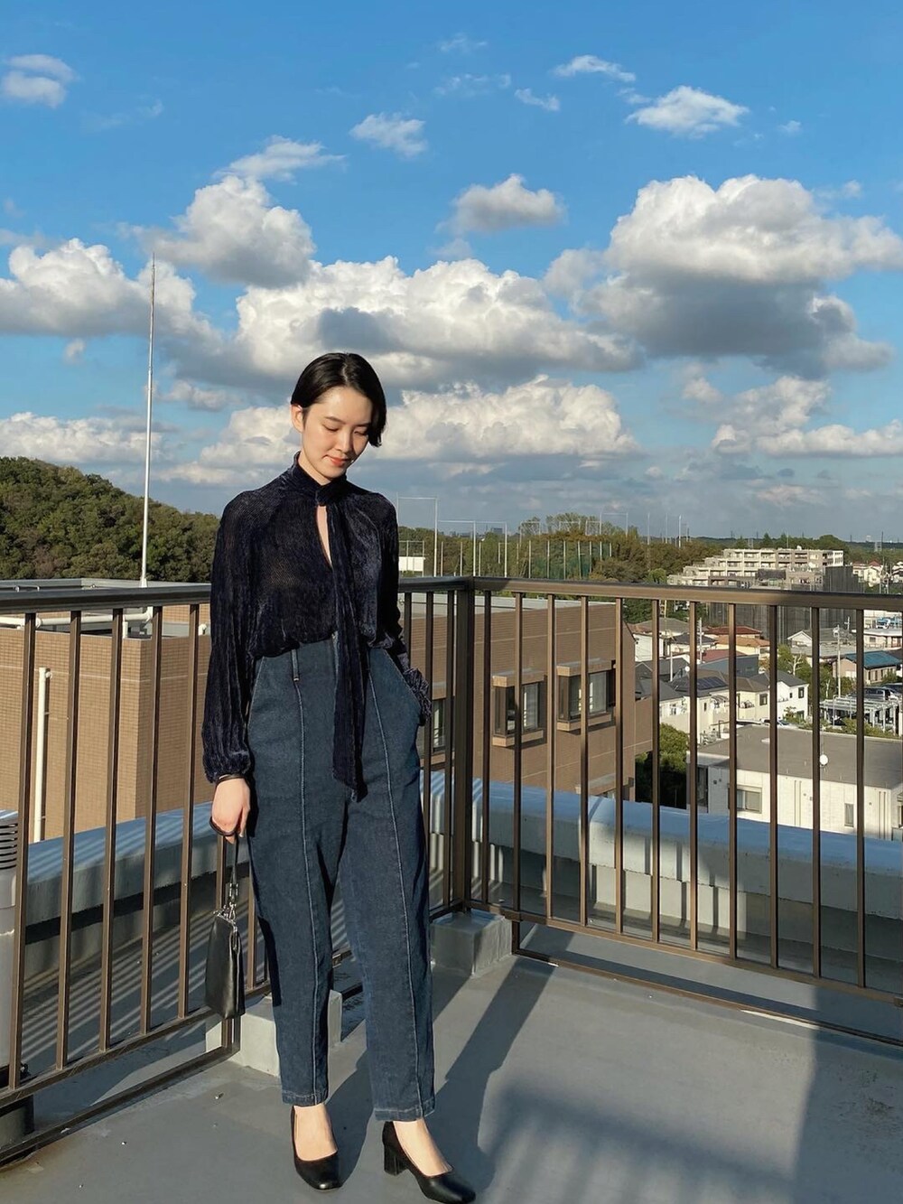 ブルー系のデニムパンツ、ブルー系のシャツ/ブラウス、ブラック系のショルダーバッグを着用したレディースの秋コーディネートの2枚目の写真