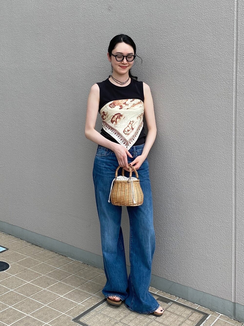 ベージュ系のかごバッグ、ブルー系のデニムパンツ、レッド系のパンプスを着用したレディースの夏コーディネートの4枚目の写真