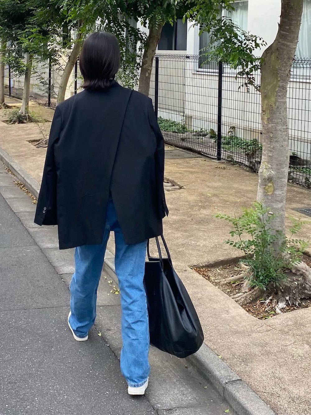 ブラック系のジャケット/アウター、ホワイト系のTシャツ/カットソー、ブラック系のバッグを着用したレディースの秋コーディネートの5枚目の写真