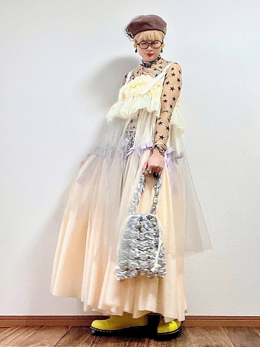 シルバー系のハンドバッグ、ベージュ系のTシャツ/カットソー、グリーン系のブルゾンを着用したレディースの秋コーディネートの2枚目の写真