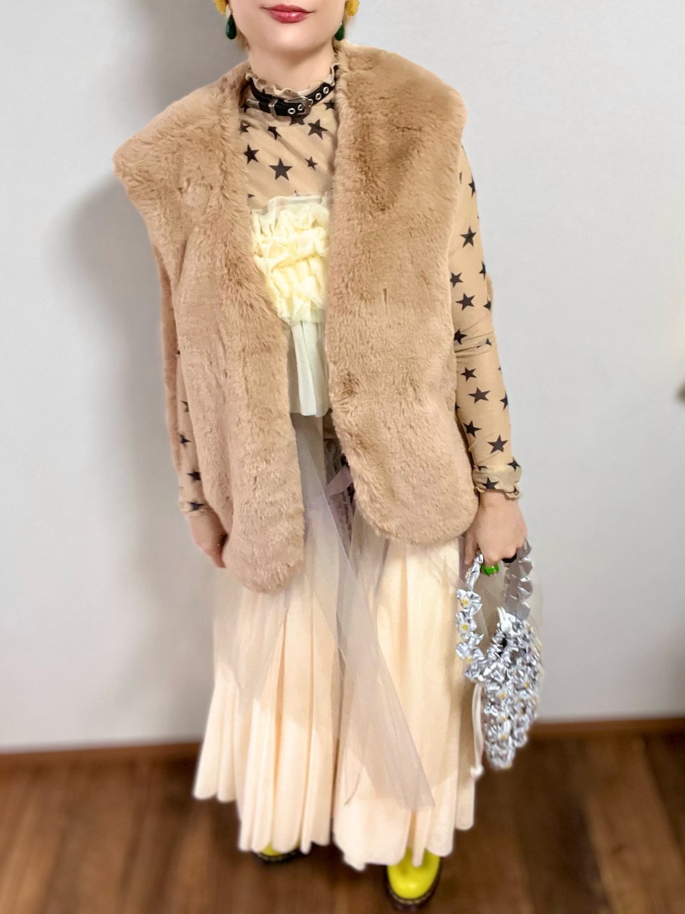 シルバー系のハンドバッグ、ベージュ系のTシャツ/カットソー、グリーン系のブルゾンを着用したレディースの秋コーディネートの3枚目の写真