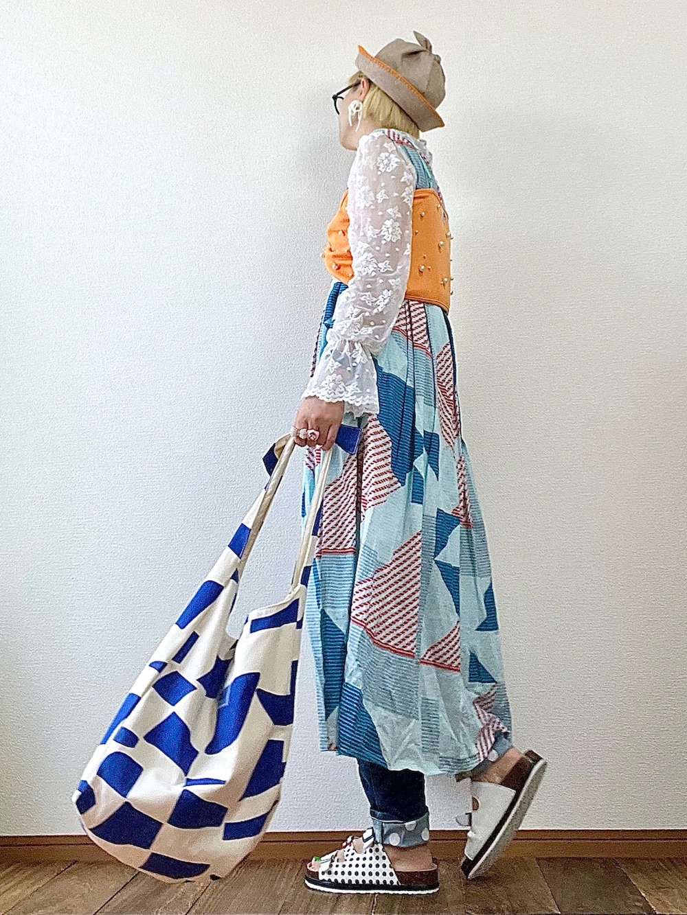 オレンジ系のTシャツ/カットソー、ホワイト系のシャツ/ブラウス、ブルー系のデニムパンツを着用したレディースの夏コーディネートの2枚目の写真