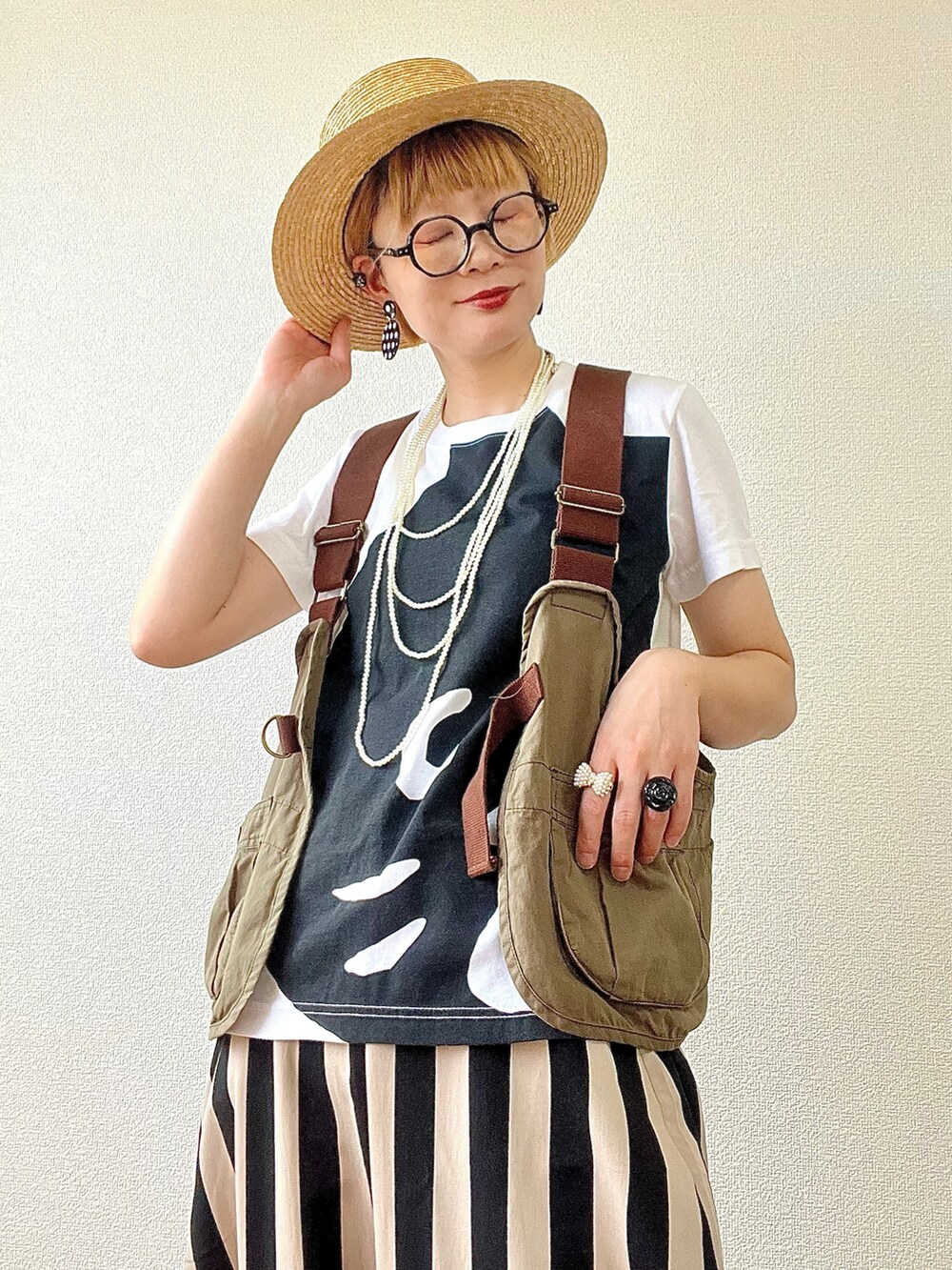 ホワイト系のTシャツ/カットソー、グリーン系のベスト、ブラック系のその他パンツを着用したレディースの春コーディネートの3枚目の写真