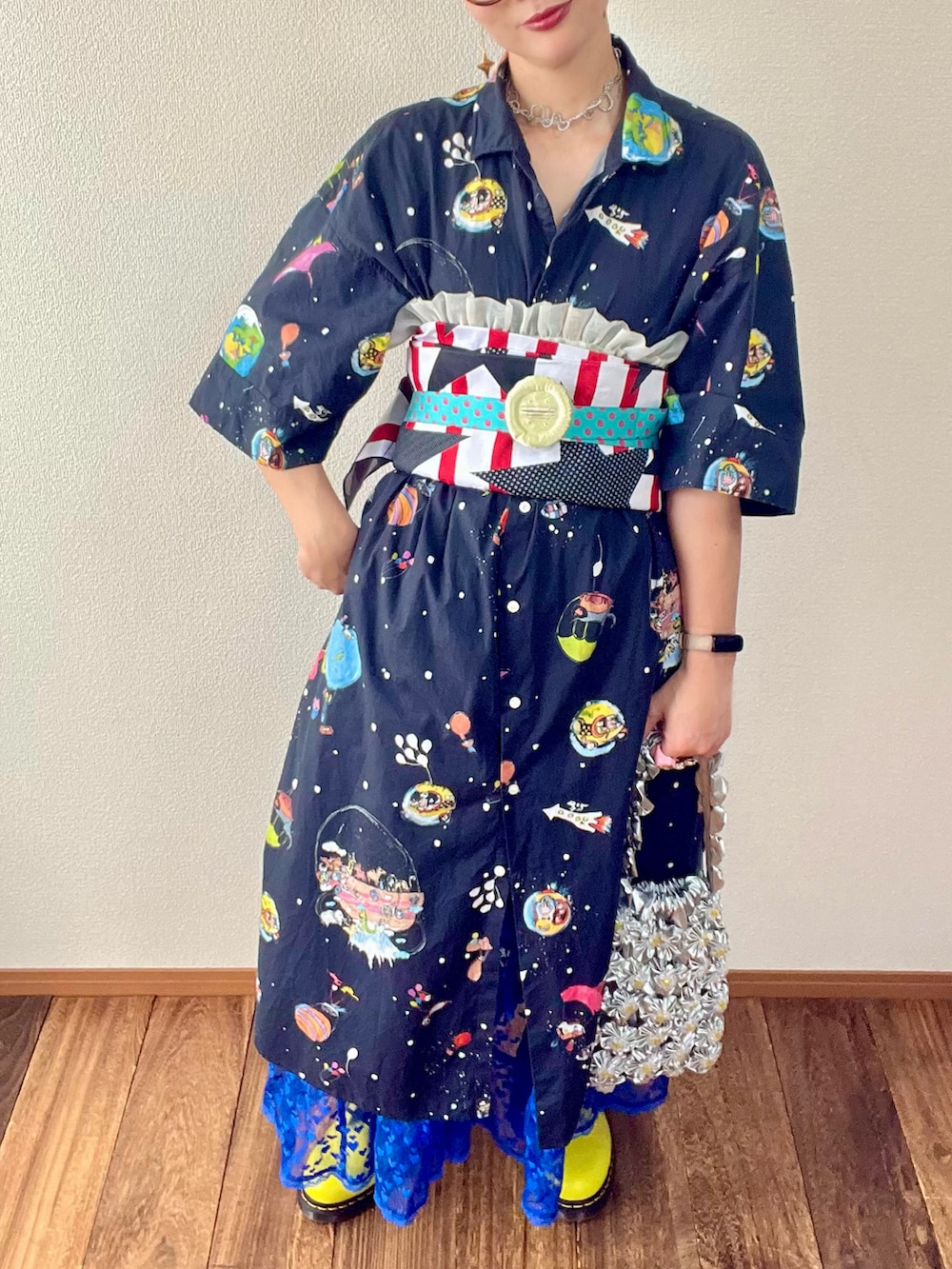 ブルー系のスカート、その他のワンピース、ブラック系のハンドバッグを着用したレディースの夏コーディネートの3枚目の写真