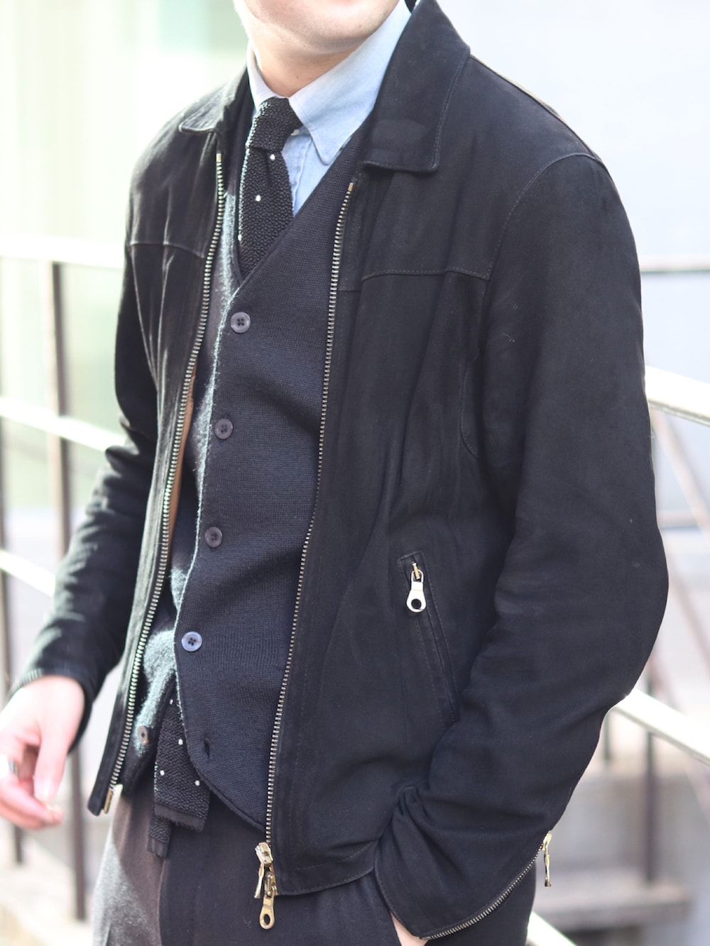 ブラック系のライダースジャケット、ブラック系のネクタイ、ブルー系のシャツ/ブラウスを着用したメンズの冬コーディネートの2枚目の写真