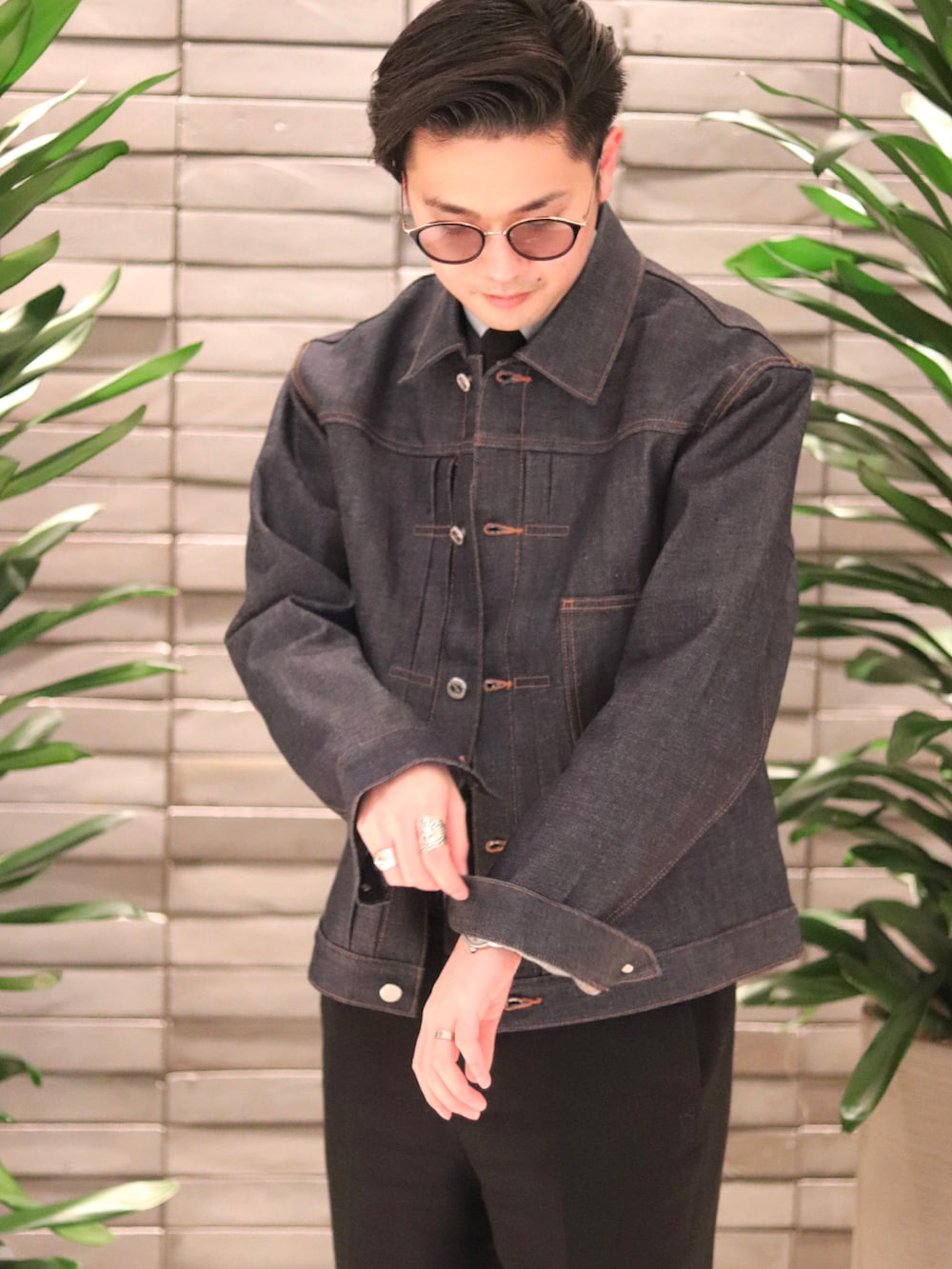 ブルー系のデニムジャケット、ブラック系のネクタイ、ブラック系のスーツジャケットを着用したメンズの冬コーディネートの3枚目の写真