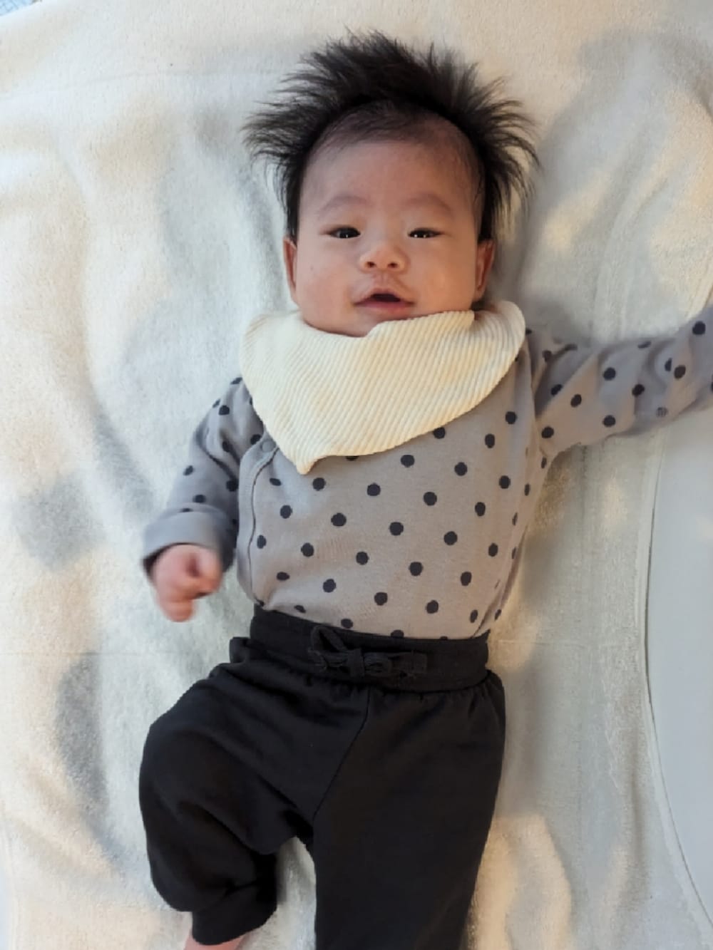 グレー系の肌着、ブラック系のその他ベビーウェア、ホワイト系のスタイ/よだれかけを着用したキッズの冬コーディネートの2枚目の写真