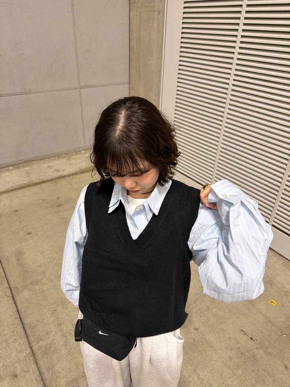 グレー系のスウェットパンツ、ブラック系のパンプス、ブルー系のシャツ/ブラウスを着用したレディースの冬コーディネートの3枚目の写真