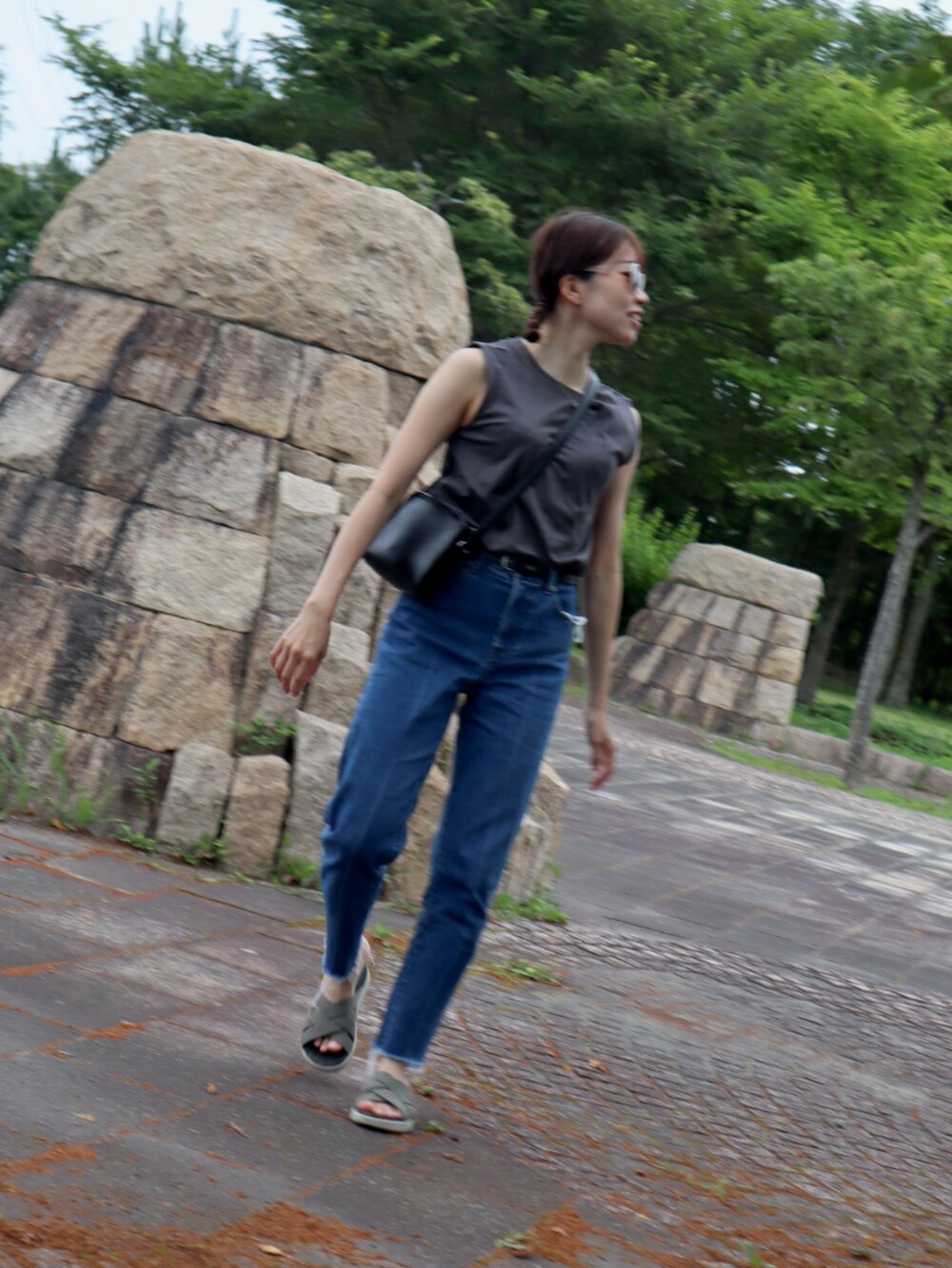 グリーン系のサンダル、ブルー系のデニムパンツ、グレー系のタンクトップを着用したレディースの夏コーディネートの4枚目の写真