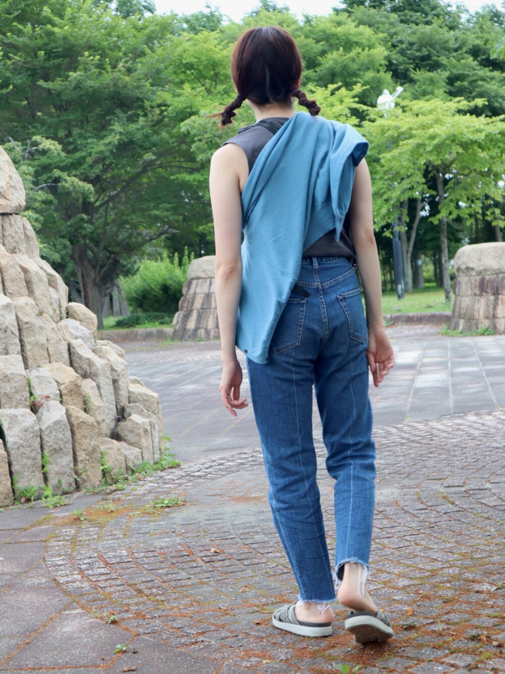 グリーン系のサンダル、ブルー系のデニムパンツ、グレー系のタンクトップを着用したレディースの夏コーディネートの3枚目の写真