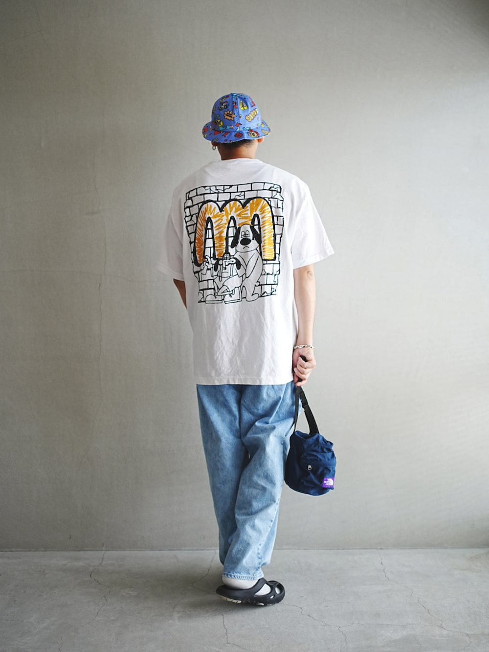 ホワイト系のTシャツ/カットソー、ブルー系のバックパック/リュック、ブルー系のデニムパンツを着用したメンズの夏コーディネートの2枚目の写真